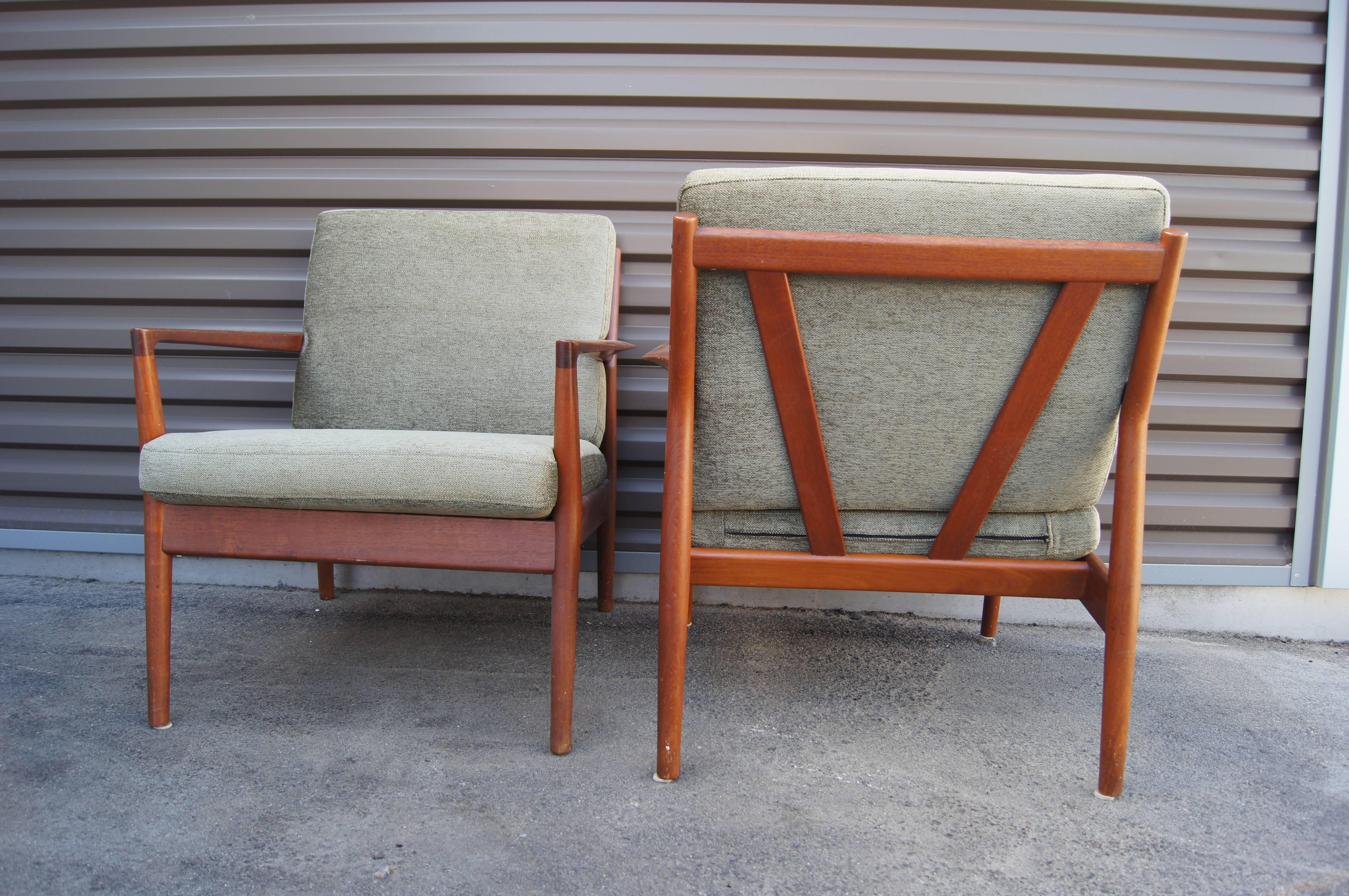 Created by Borge Jensen & Sønner for Bernstorffsminde Møbelfabrik, this pair of Danish Modern lounge chairs offers a striking profile. The solid teak frames feature tapered armrests and canted V-shaped backs for a comfortable yet elegant seat. The
