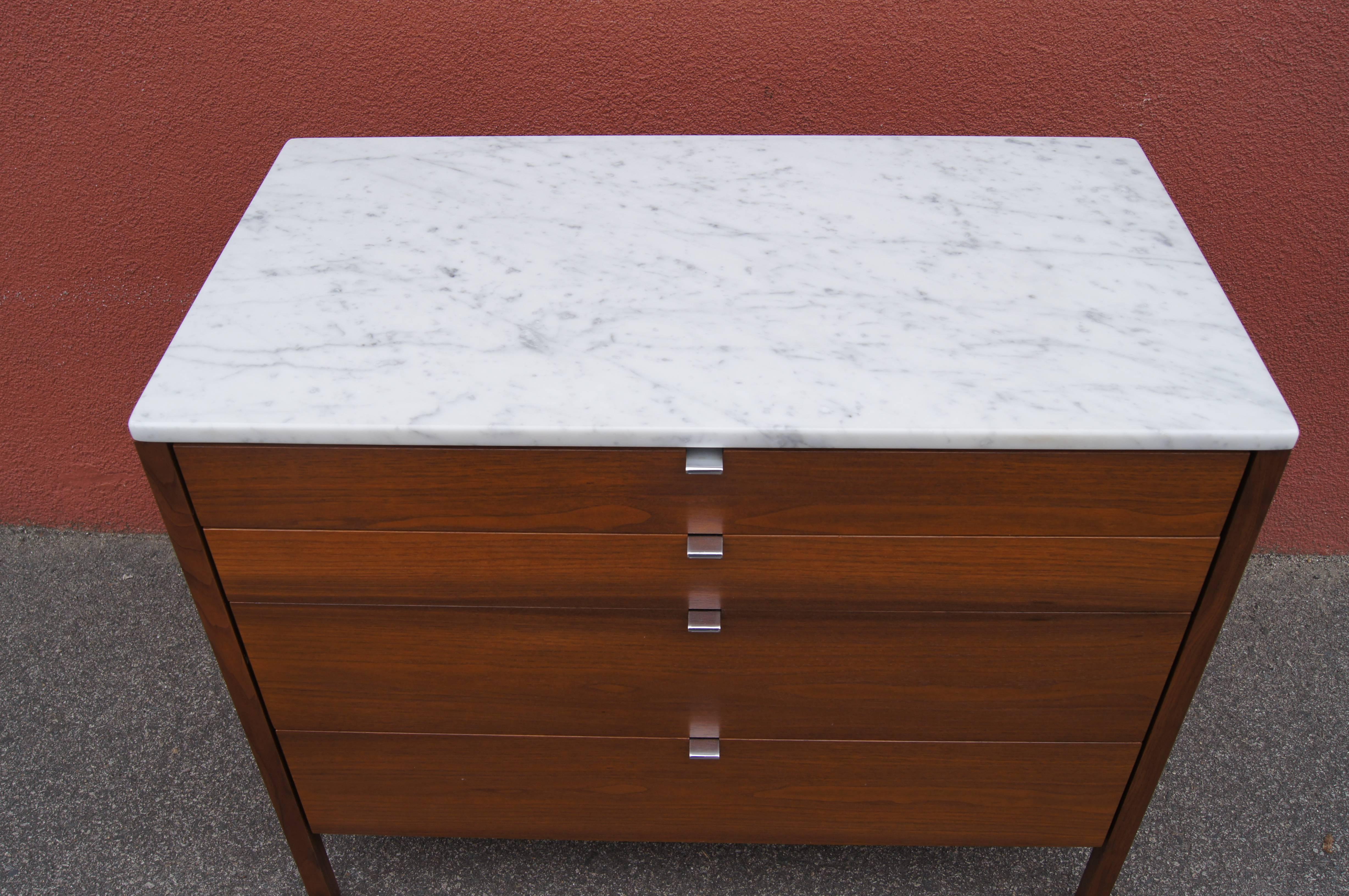 Designed in 1960 by Florence Knoll, this four-drawer dresser, model 325, has a clean-lined walnut case. This version features the luxury options of a marble top and chrome pulls.
