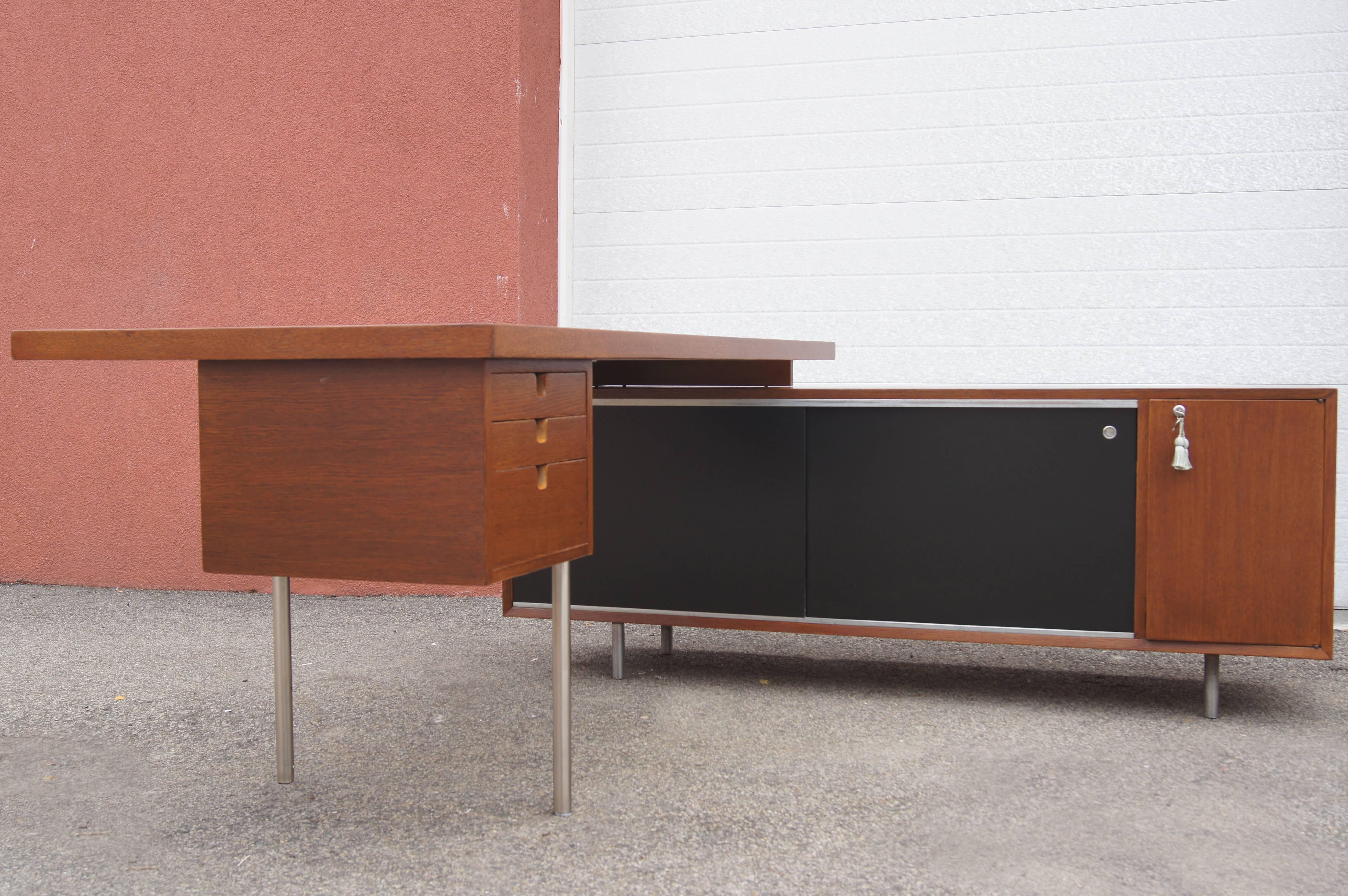Mindful of the needs of architecture firms and other creative environments, George Nelson designed this tawny walnut desk and storage unit as part of Herman Miller's Executive Office Group. A free-floating work surface (7230-L) with a three-drawer
