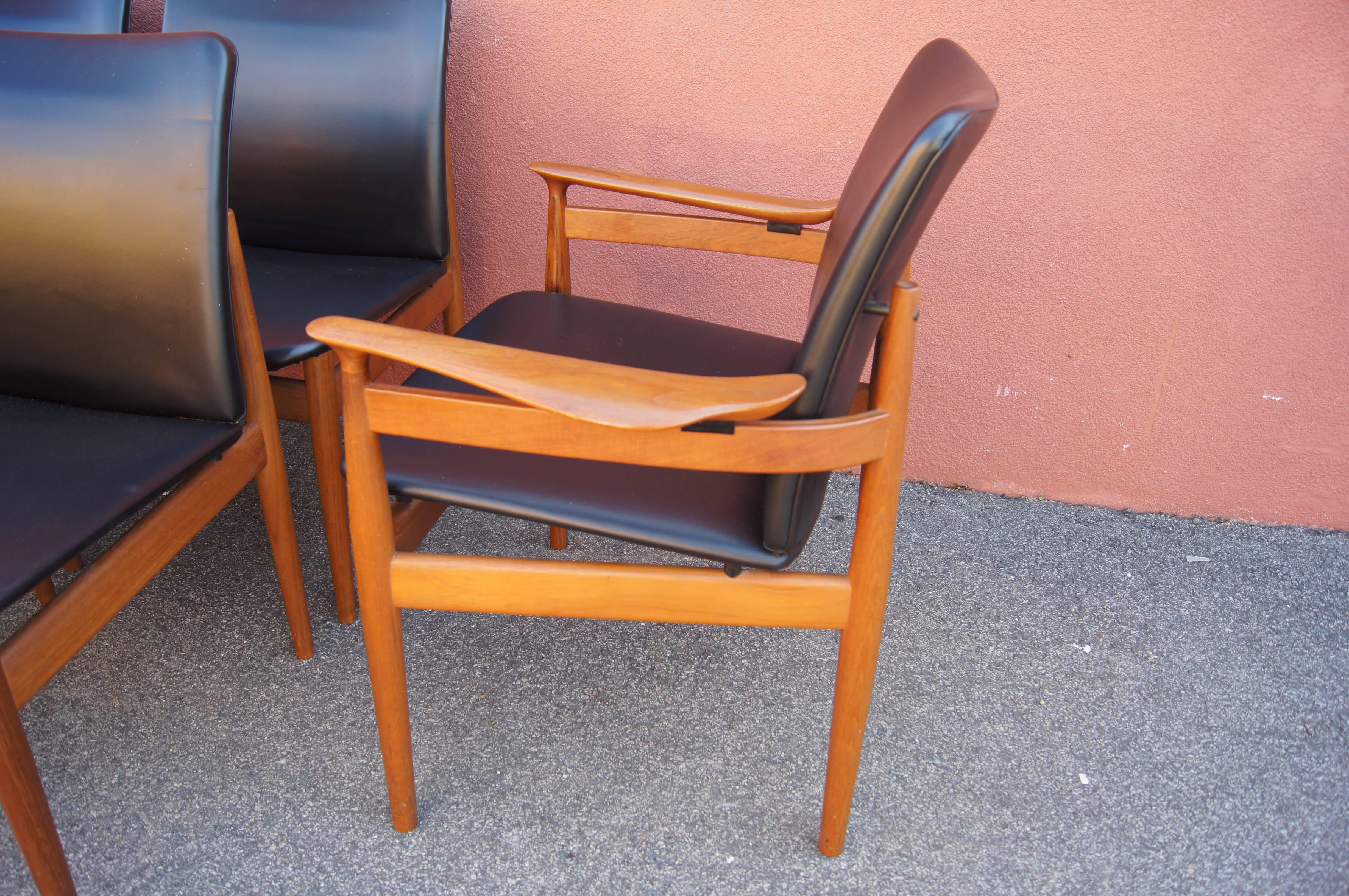 Conçu par Finn Juhl pour France & Son et importé par John Stuart, ce bel ensemble de six chaises de salle à manger présente des sièges généreux qui flottent dans des cadres en teck. Ils sont recouverts de similicuir noir.

Les dimensions ci-dessous