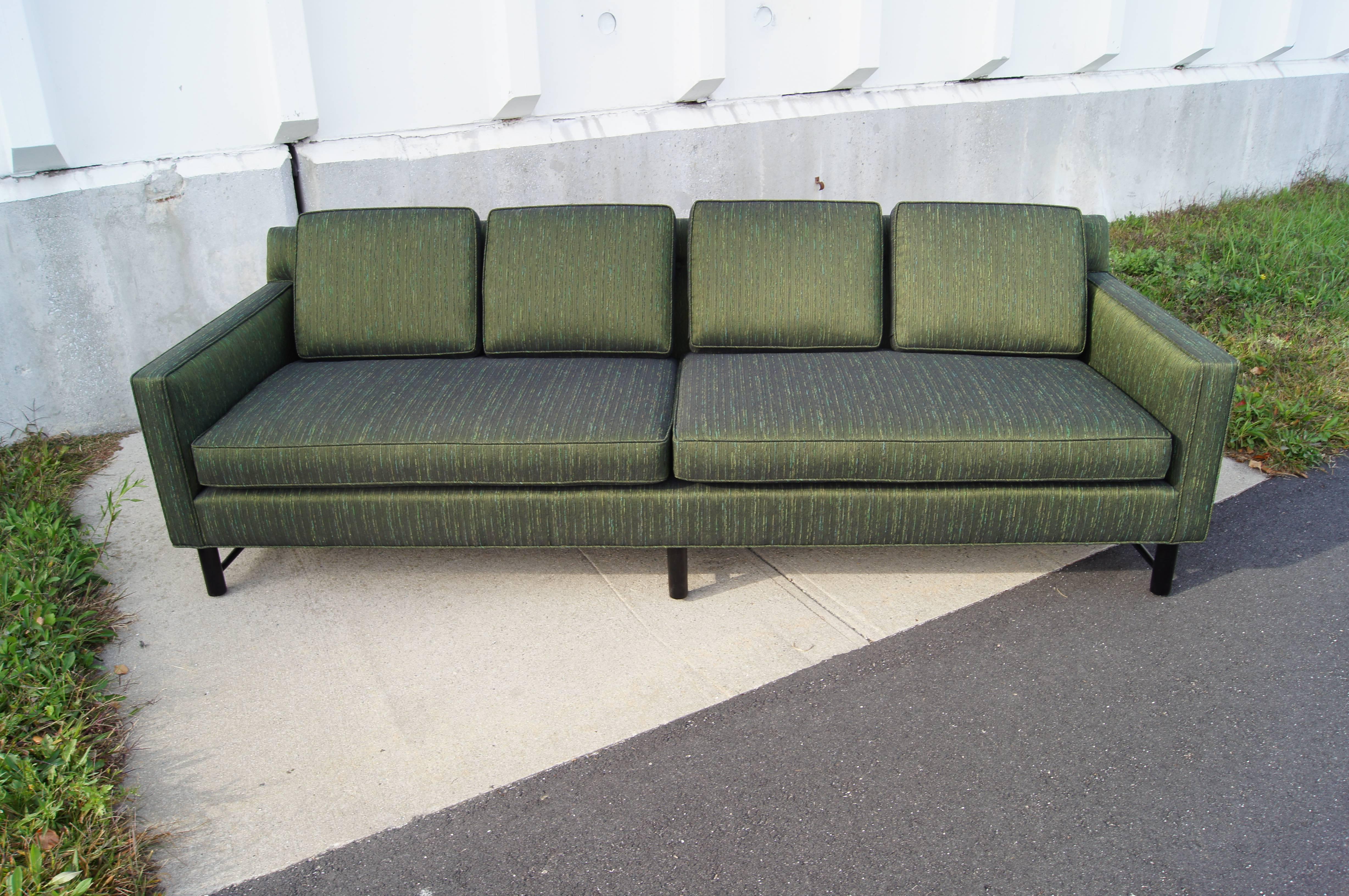 Edward Wormley designed this elegant sofa, model 5138, for Dunbar, with two large seat cushions and four down-filled back pillows.

It has been newly reupholstered in a lustrous sea green textile and its mahogany base expertly refinished and