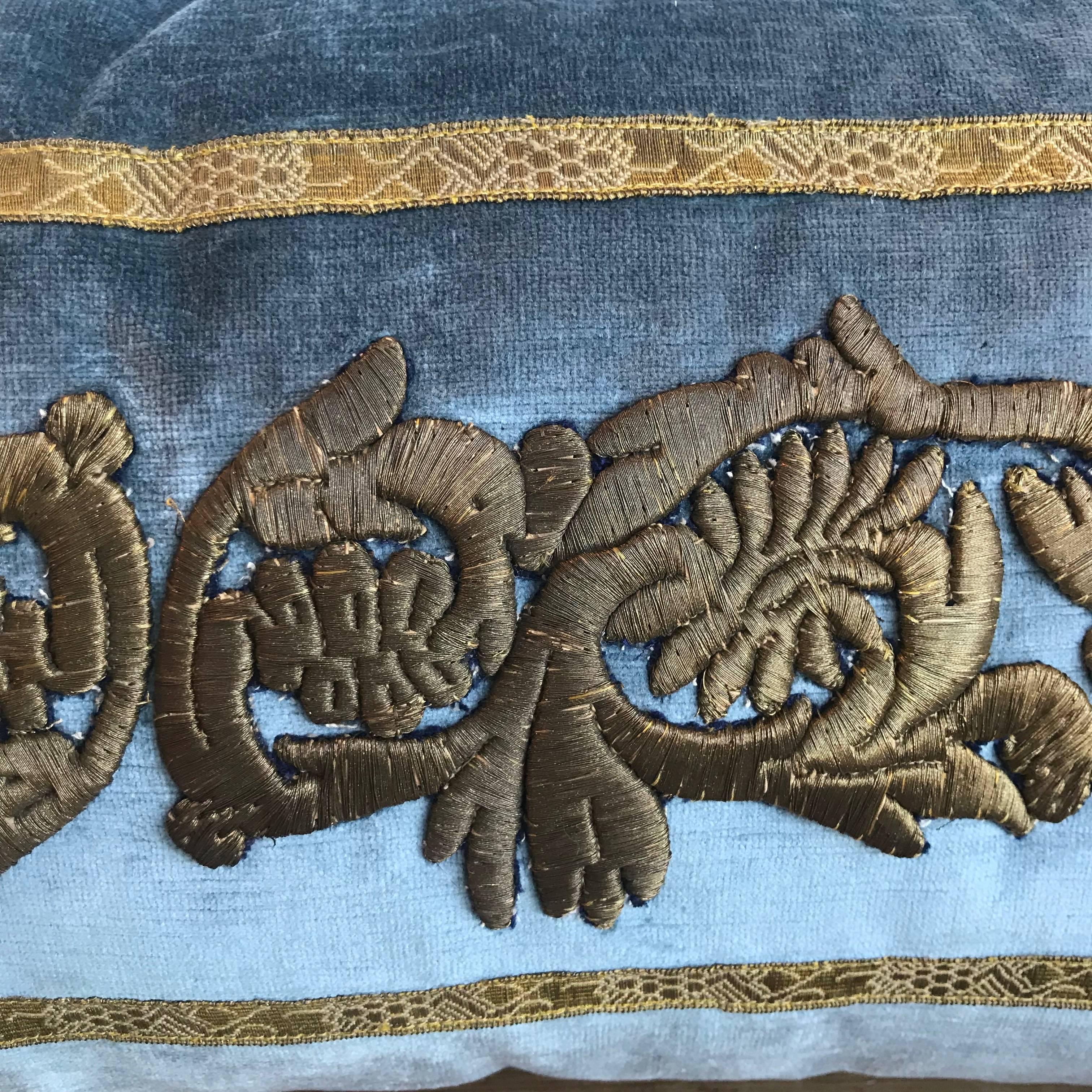 Antique raised gold metallic embroidery thought to be Egyptian or Syrian bordered with antique European gold metallic galon on wedgewood blue velvet. Hand trimmed with gold metallic cording knotted in the corners. Down filled.