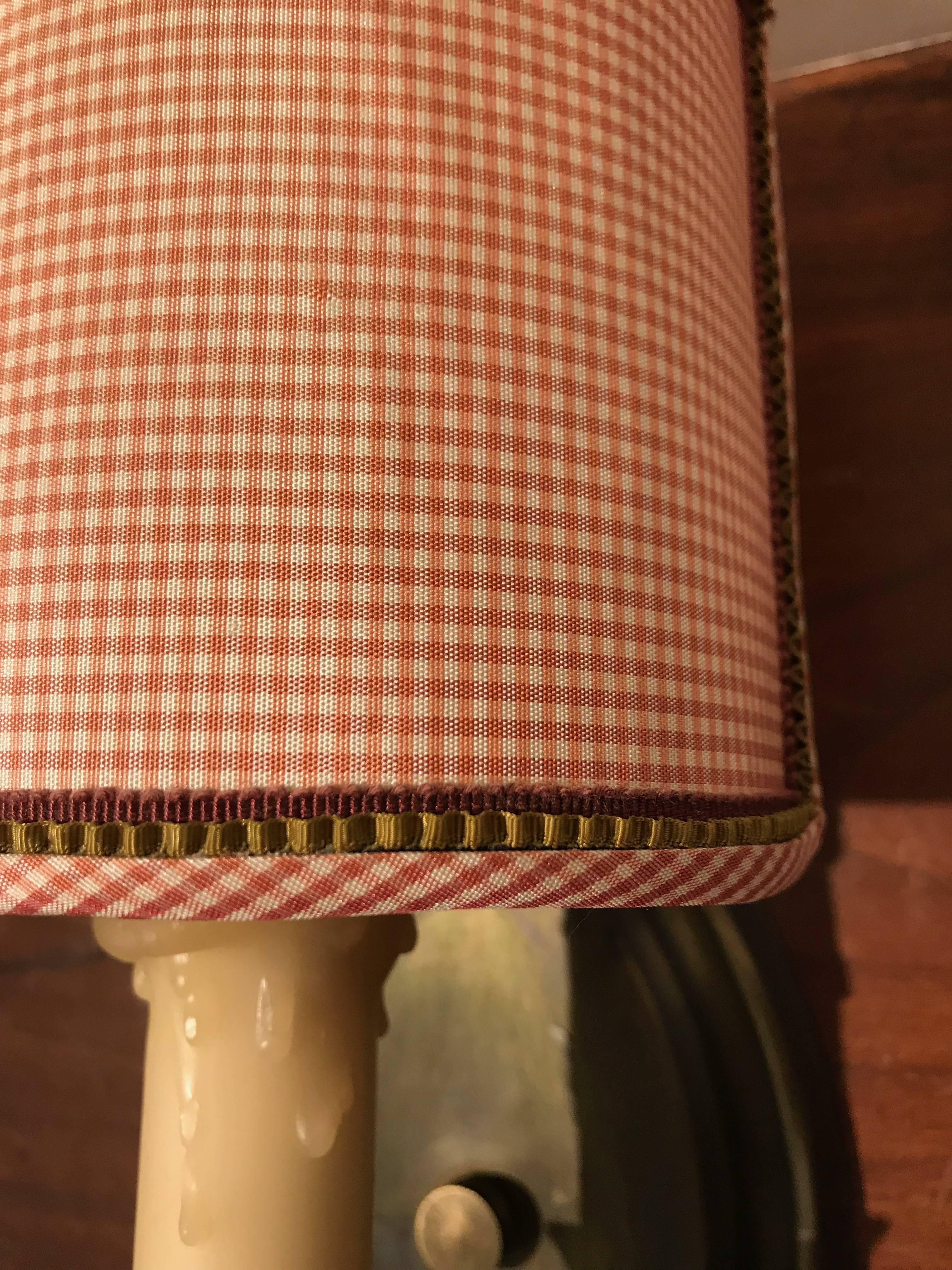 Trimmed gingham shades on brass sconces.