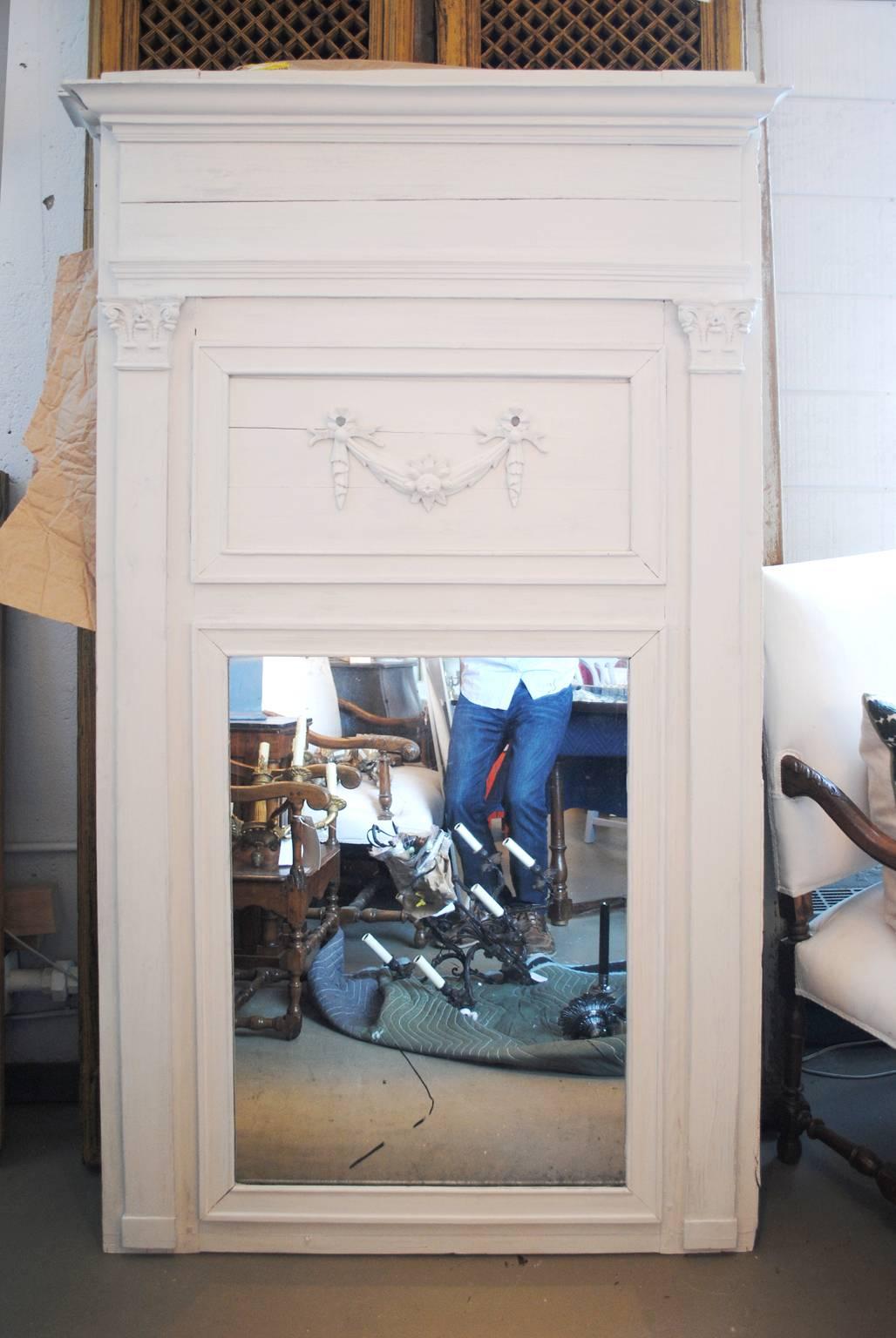 Pair of large-scale painted trumeau mirrors with decorative swag and floral rosette. Original mirrors.