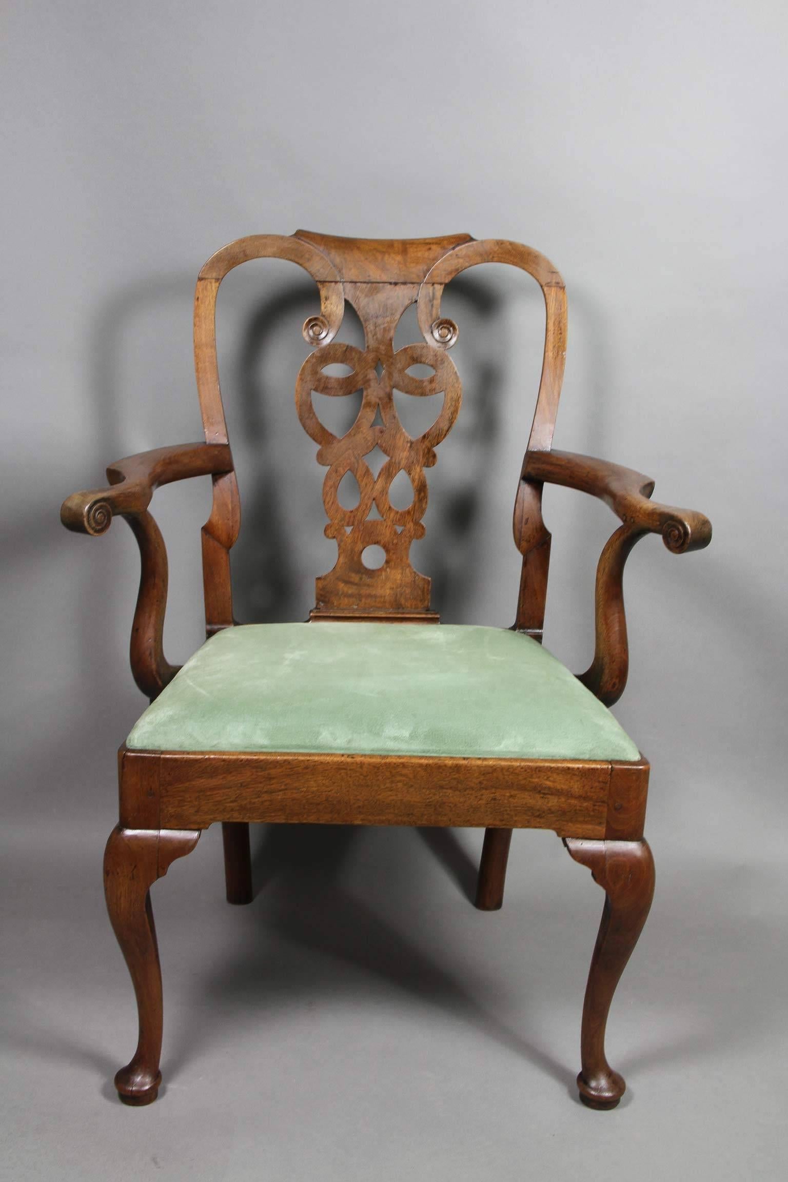 Arched crestrail over a central pierced and carved splat, outscrolled arms joining the seat frame with drop in padded seat, raised on cabriole legs ending on pad feet.