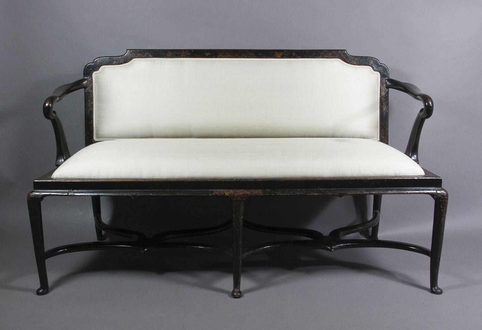 Low shaped upholstered back and crook shaped arms and upholstered seat set in a conforming frame raised on slight cabriole legs joined by shaped stretchers ending on pad feet. Provenance: Worcester Art Museum, Worcester Ma.