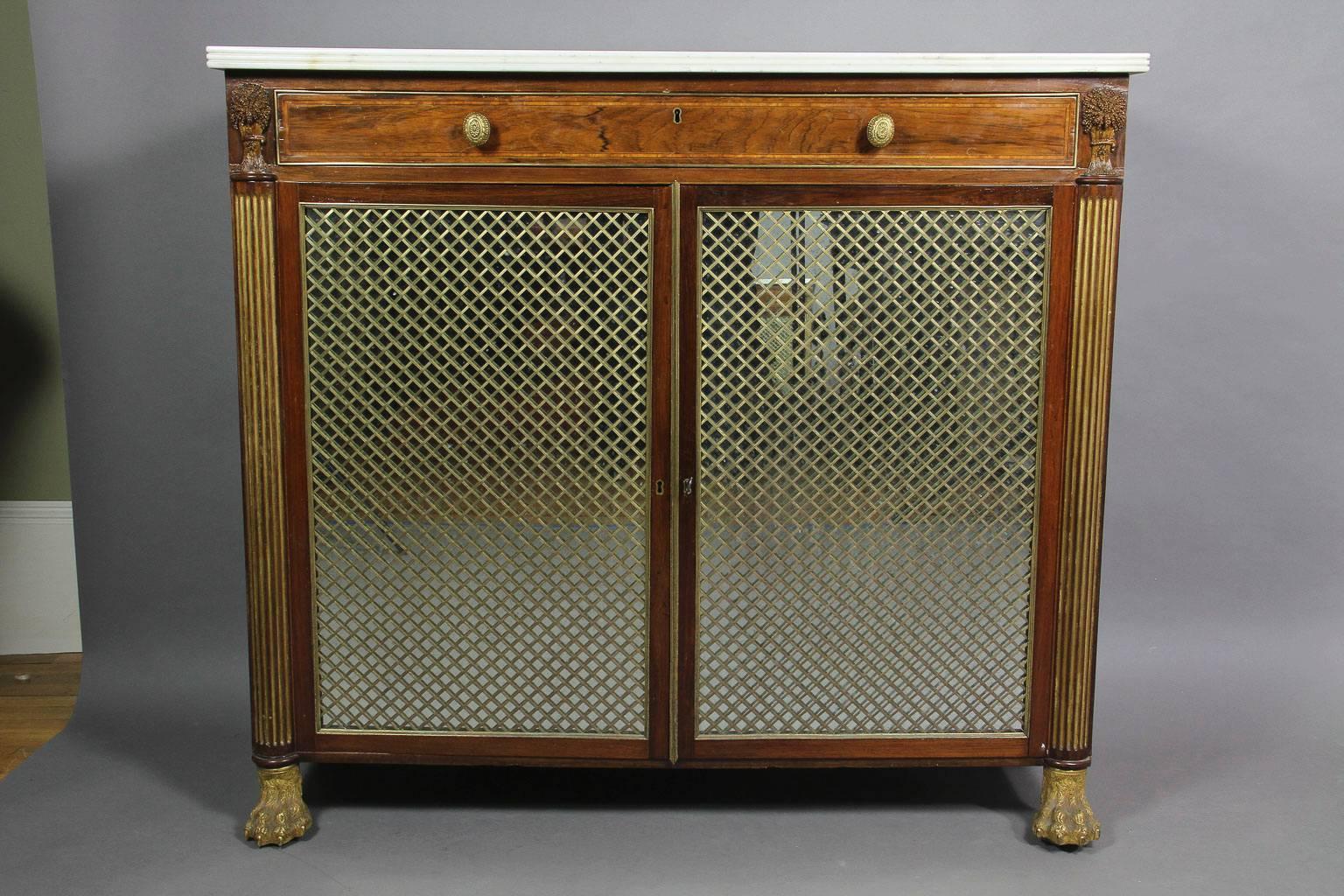 Rectangular reeded edge white marble-top over a case with a central drawer flanked by cornucopia all-over a pair of mirrored grill doors, raised on cast bronze lion feet.