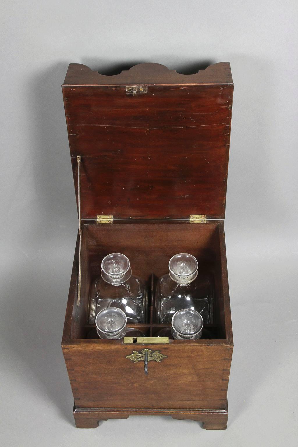 Square top with compartments for four bottles over a dovetailed case opening to storage for four bottles, bracket feet. Includes four original bottles.