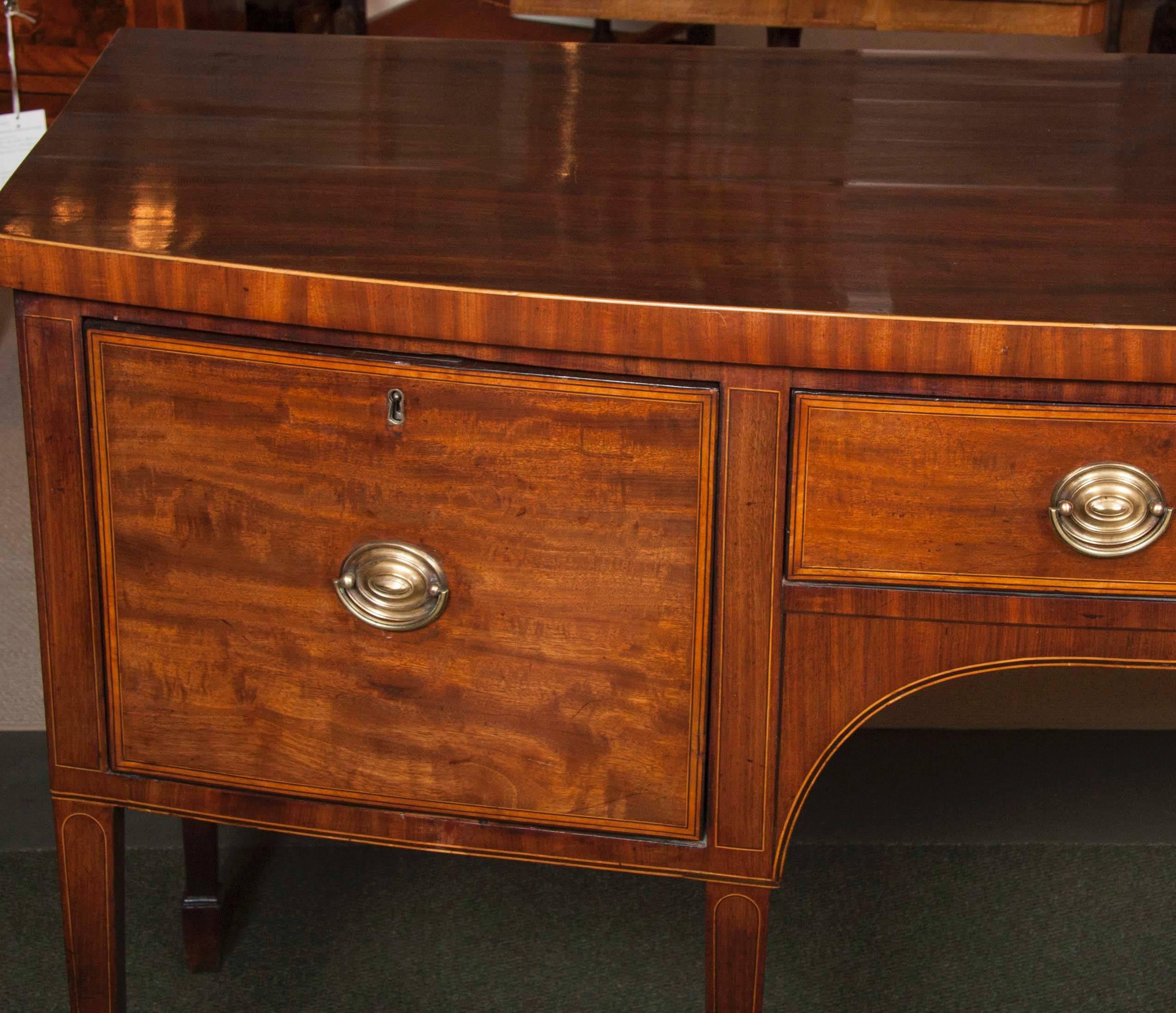 Bow fronted with a long drawer flanked by two deep drawers raised on square tapered legs and spade feet.