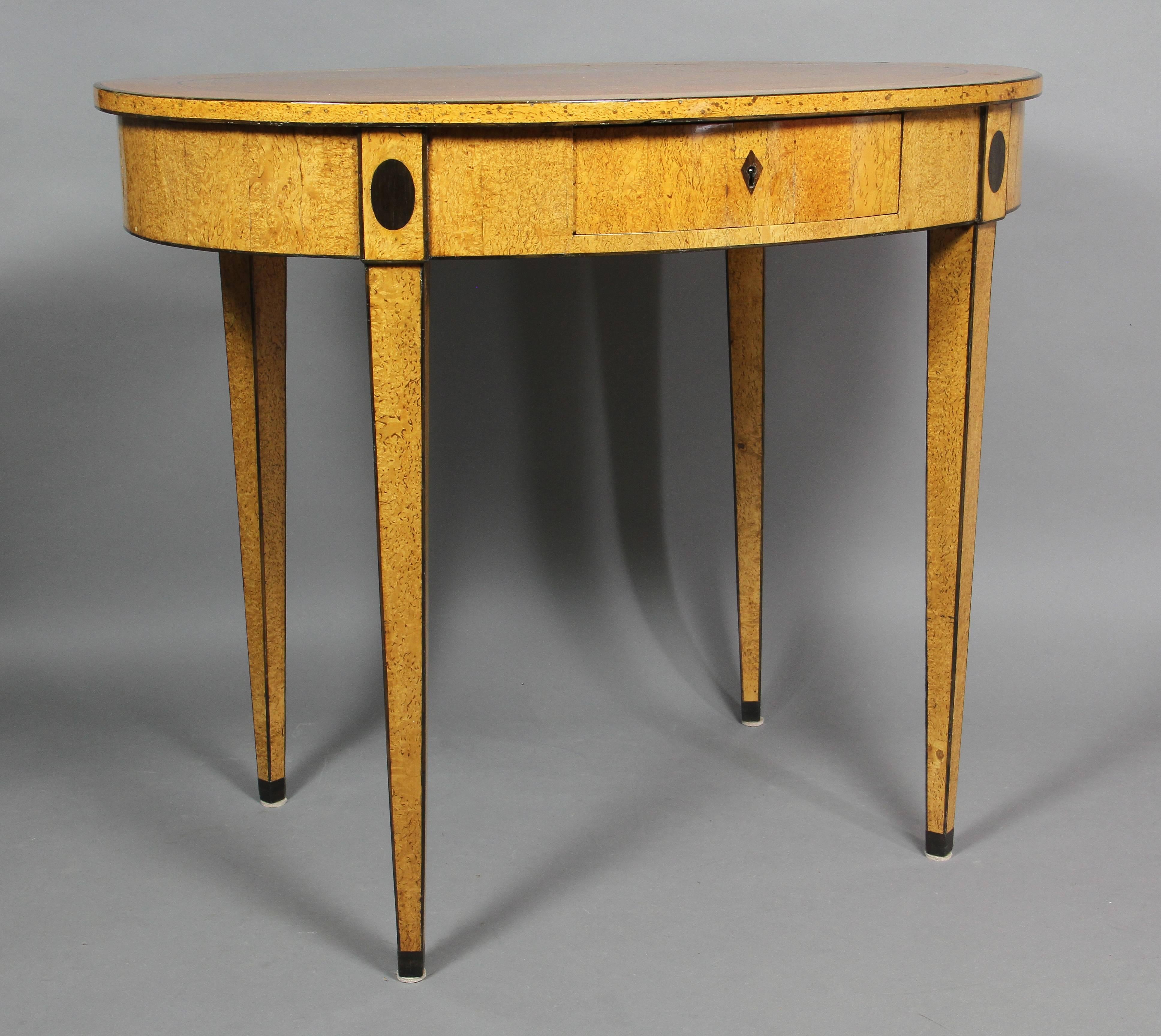 Oval top over a drawer with diamond shape escutcheon and flanked by oval inlays raised on square tapered legs. Provenance: Bernd Goeckler, New York.