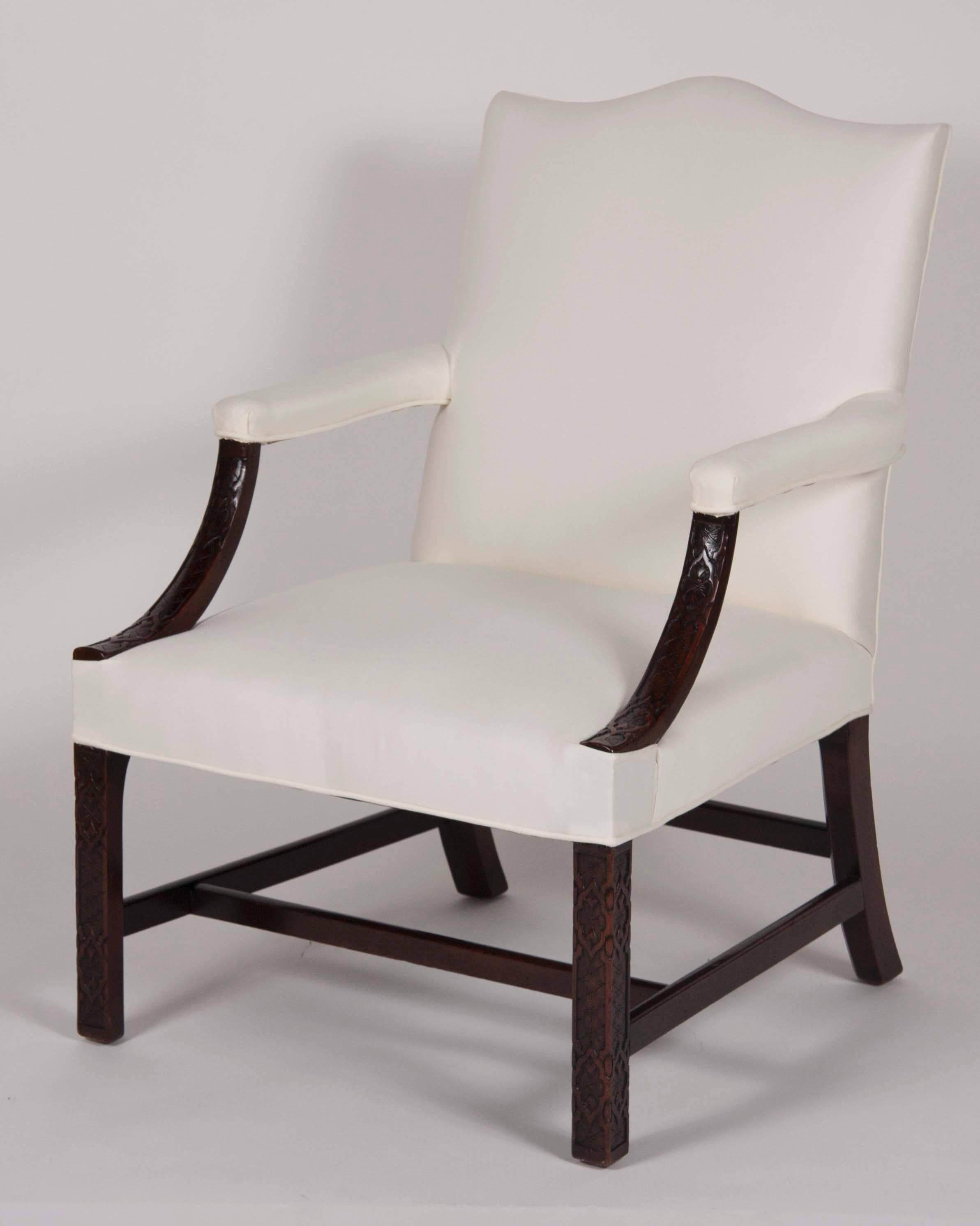 Serpentine upholstered back downswept carved arms over an upholstered seat raised on fret carved Marlborough legs joined by H-form stretchers.