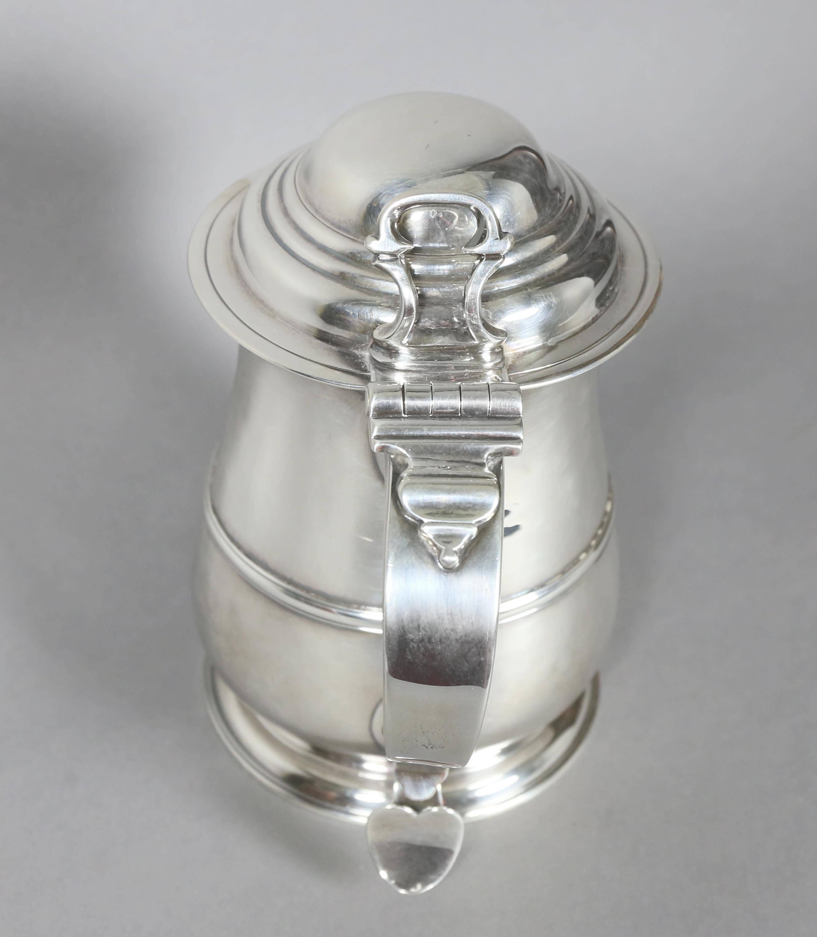 With domed hinged lid and baluster body, scroll handle. Engraved with crest.
