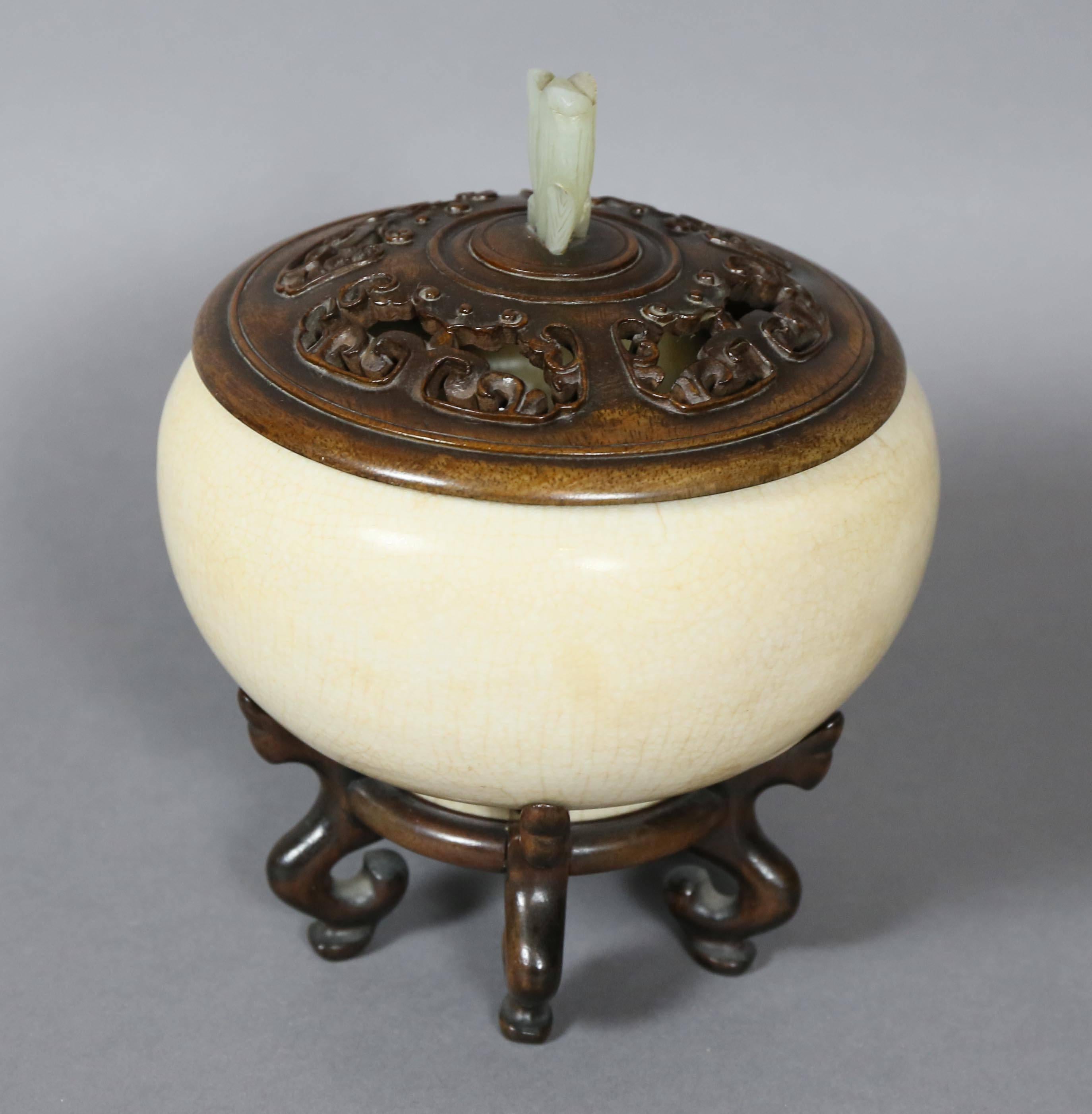 With pierced finely carved wood lid with jade finial, globular shaped heavily potted bowl on a wood stand.