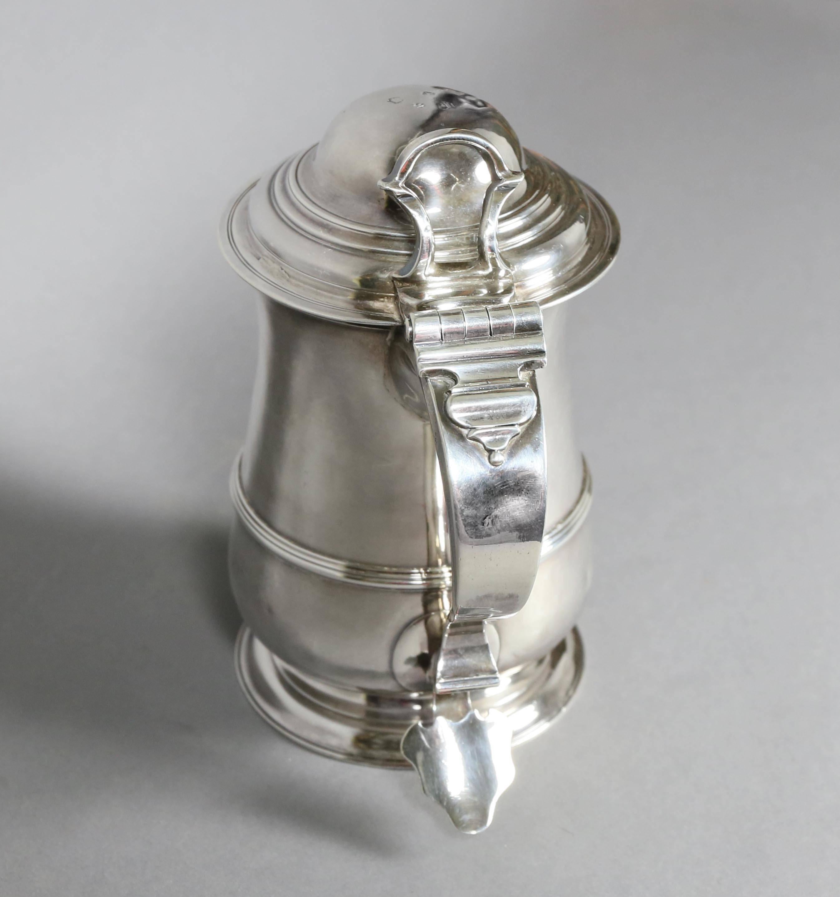 George II Sterling tankard with domed hinged lid and baluster form body, shaped scroll handle. Dated 1745. 26 troy ounces.