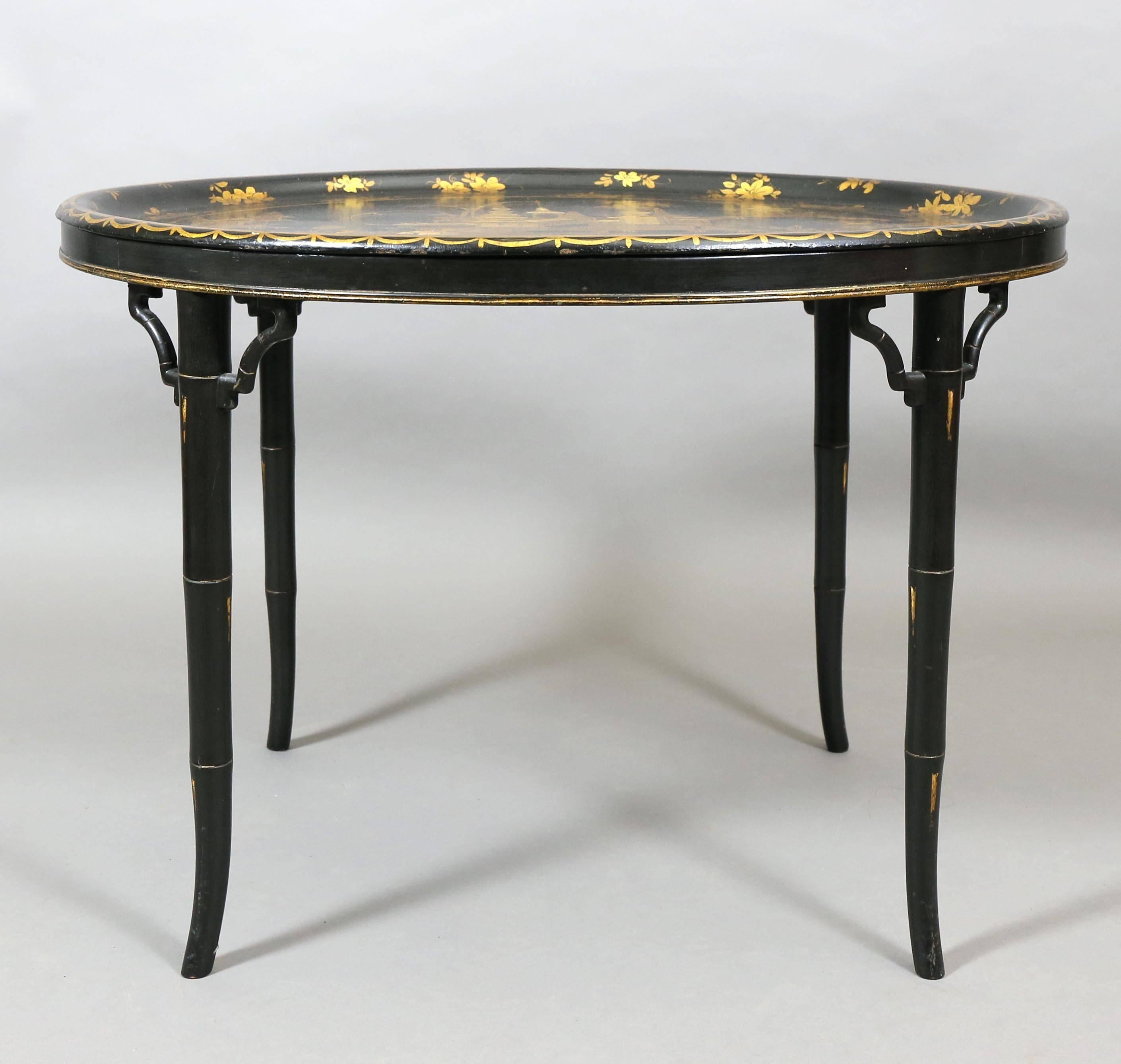 Oval top with gilded oriental scenes, the conforming base with bamboo turned legs.