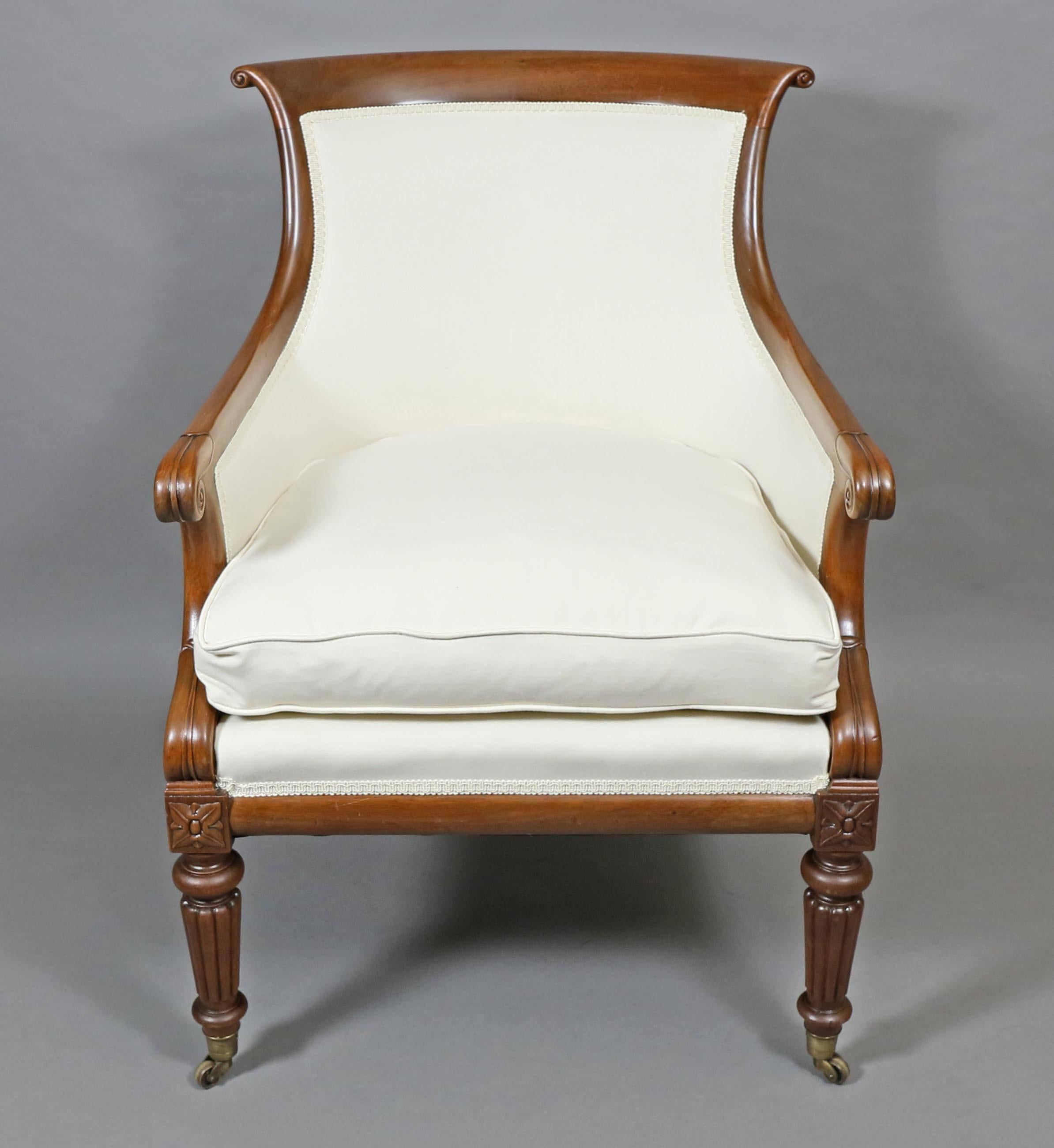 With curved scrolled crestrail over an upholstered back and seat with loose cushion, carved arms, raised on circular tapered reeded legs, casters.