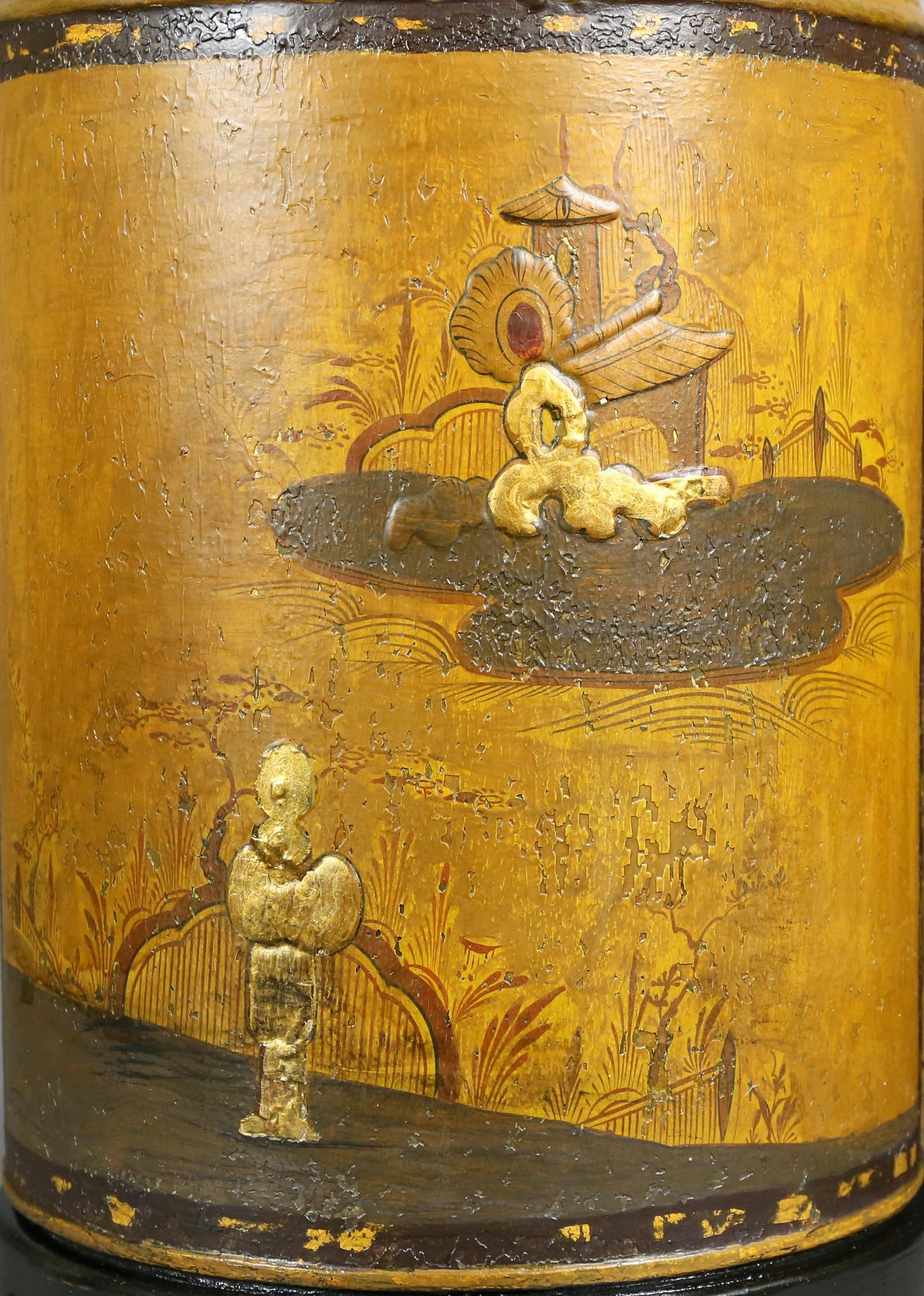 Mustard yellow tea canisters with chinoiserie decoration on each, depicting a figure and a small dwelling.