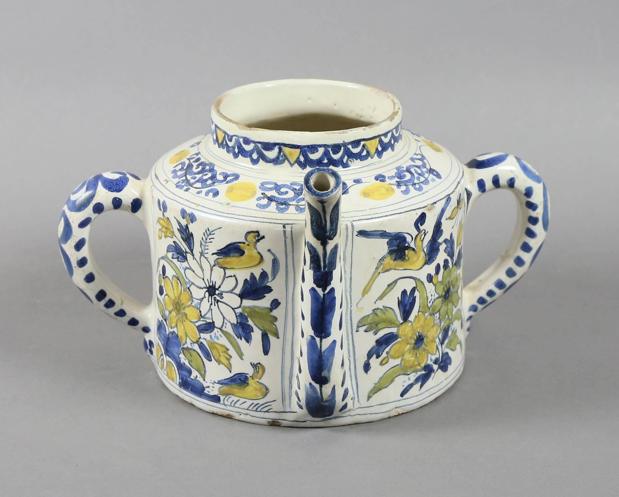 With two handles and a spout with blue and yellow floral and peacock painted decoration.