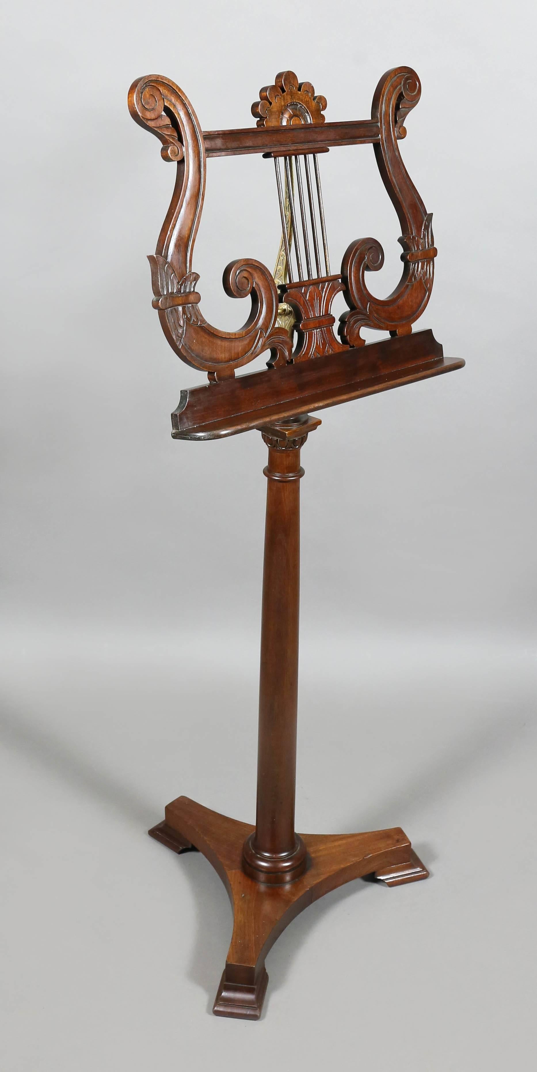 With lyre shaped carved stand on a turned support and tripartite base.