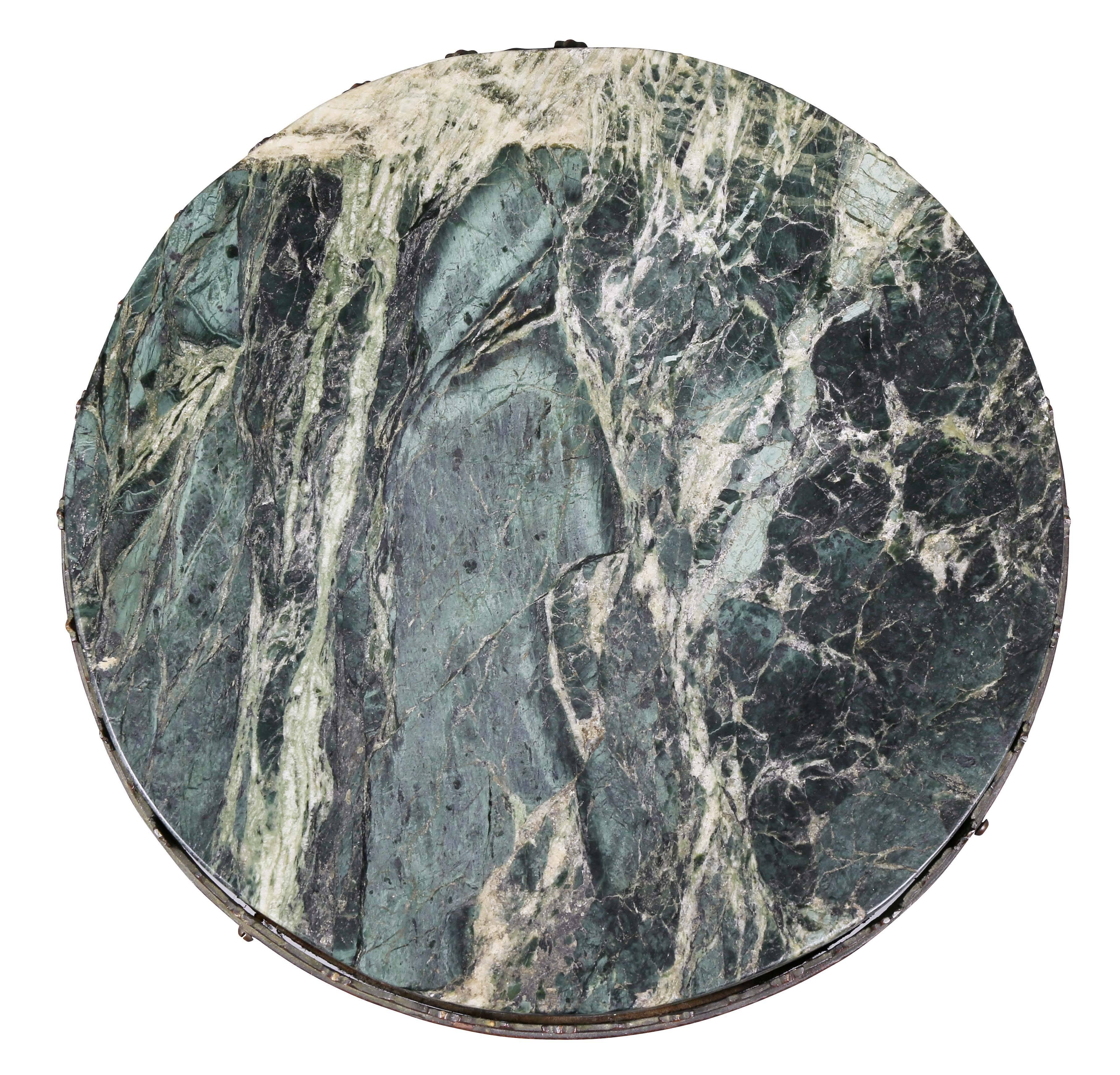 Circular with conforming inset green marble and pierced frieze raised on four legs that join a circular stretcher, bronze feet.