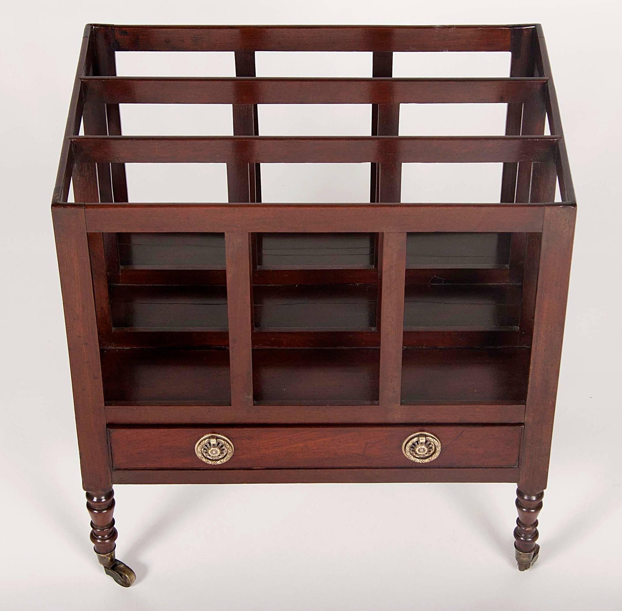 Rectangular with compartments over a drawer raised on turned legs and casters.