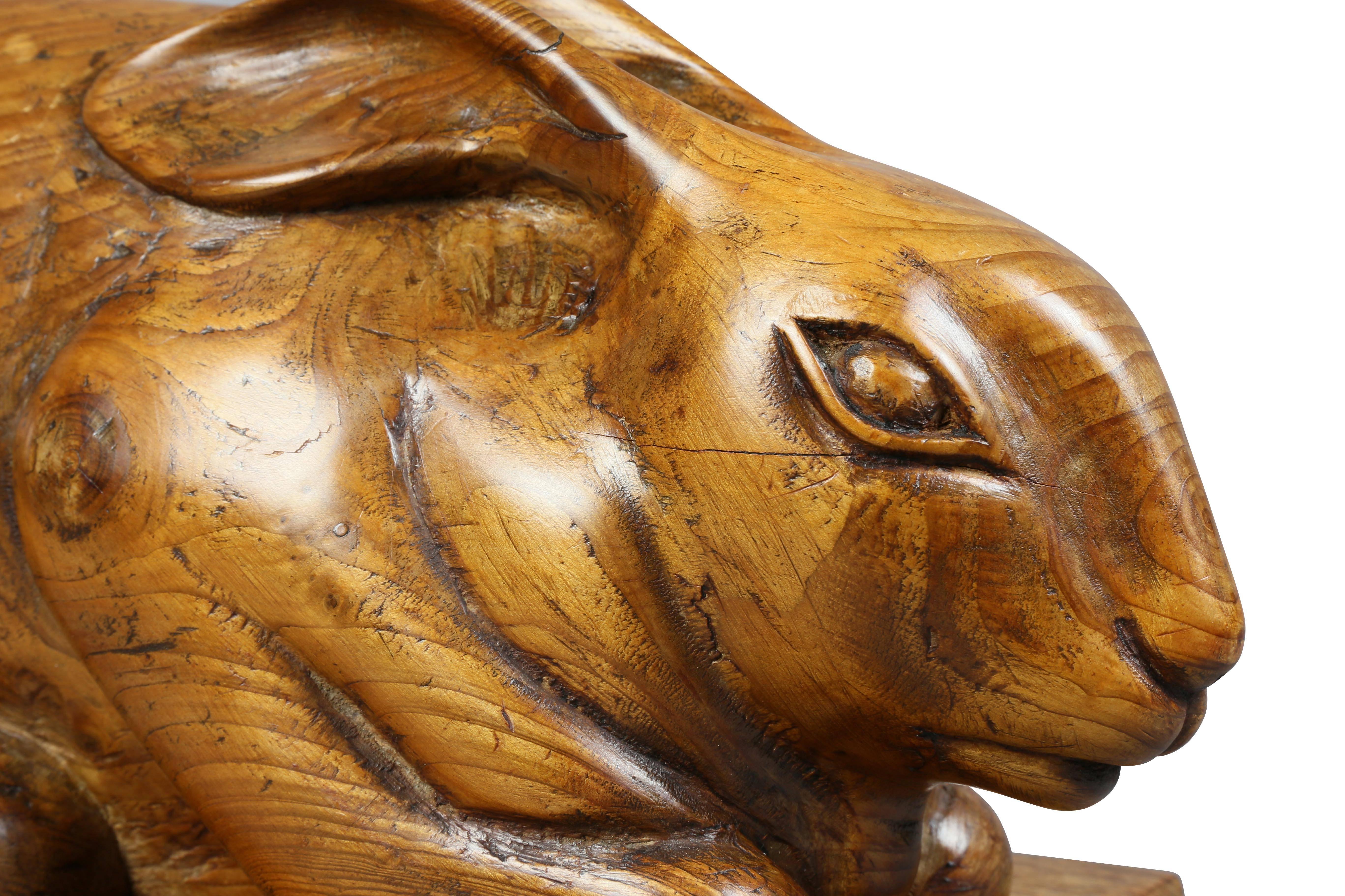 Crouching with ears tucked back on an oak beveled base with brass inscription plaque. Plaque with inscription to John Crawford of Kirkcudbright.