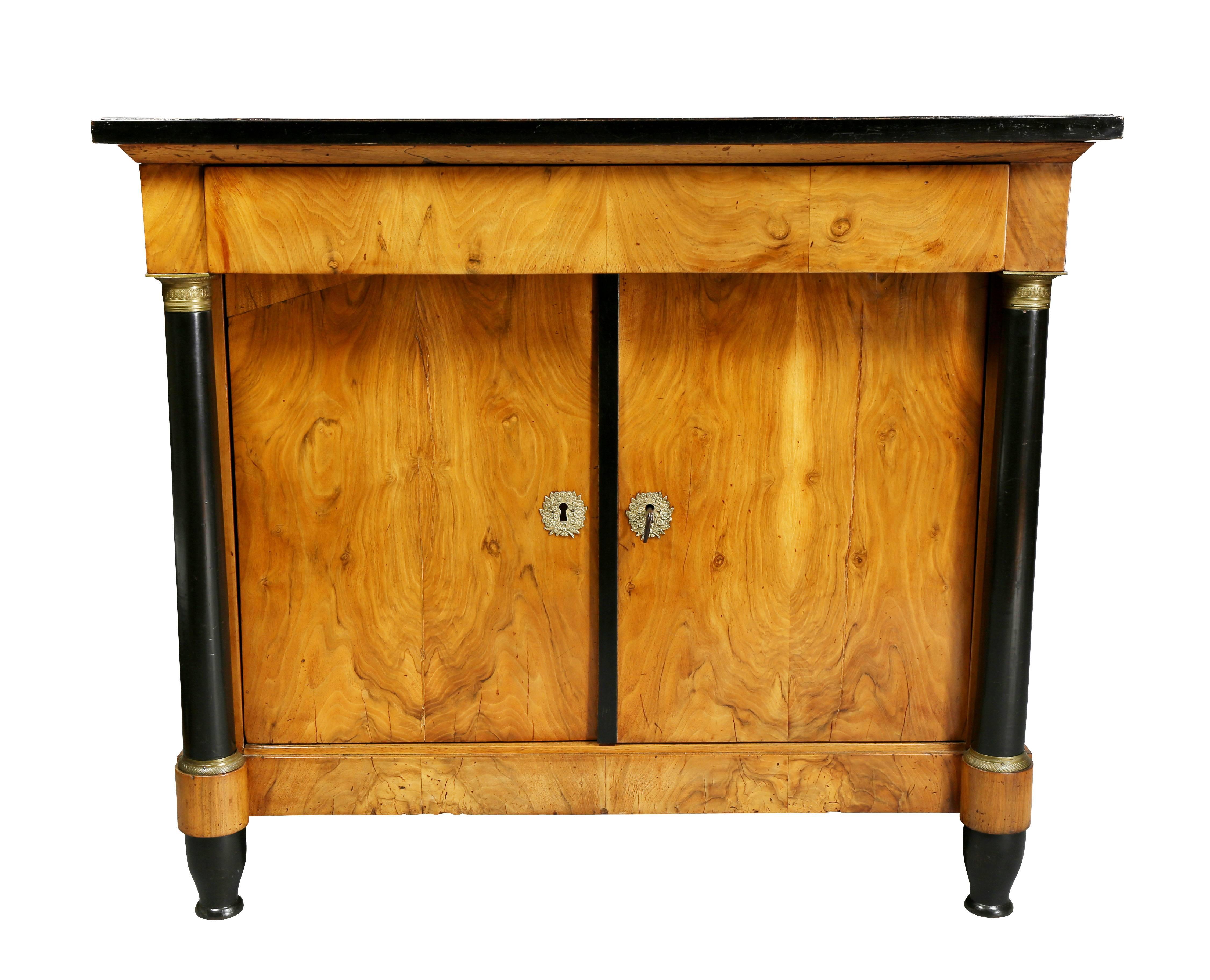 Rectangular top over a drawer and pair of cabinet doors flanked by columns raised on turned feet.