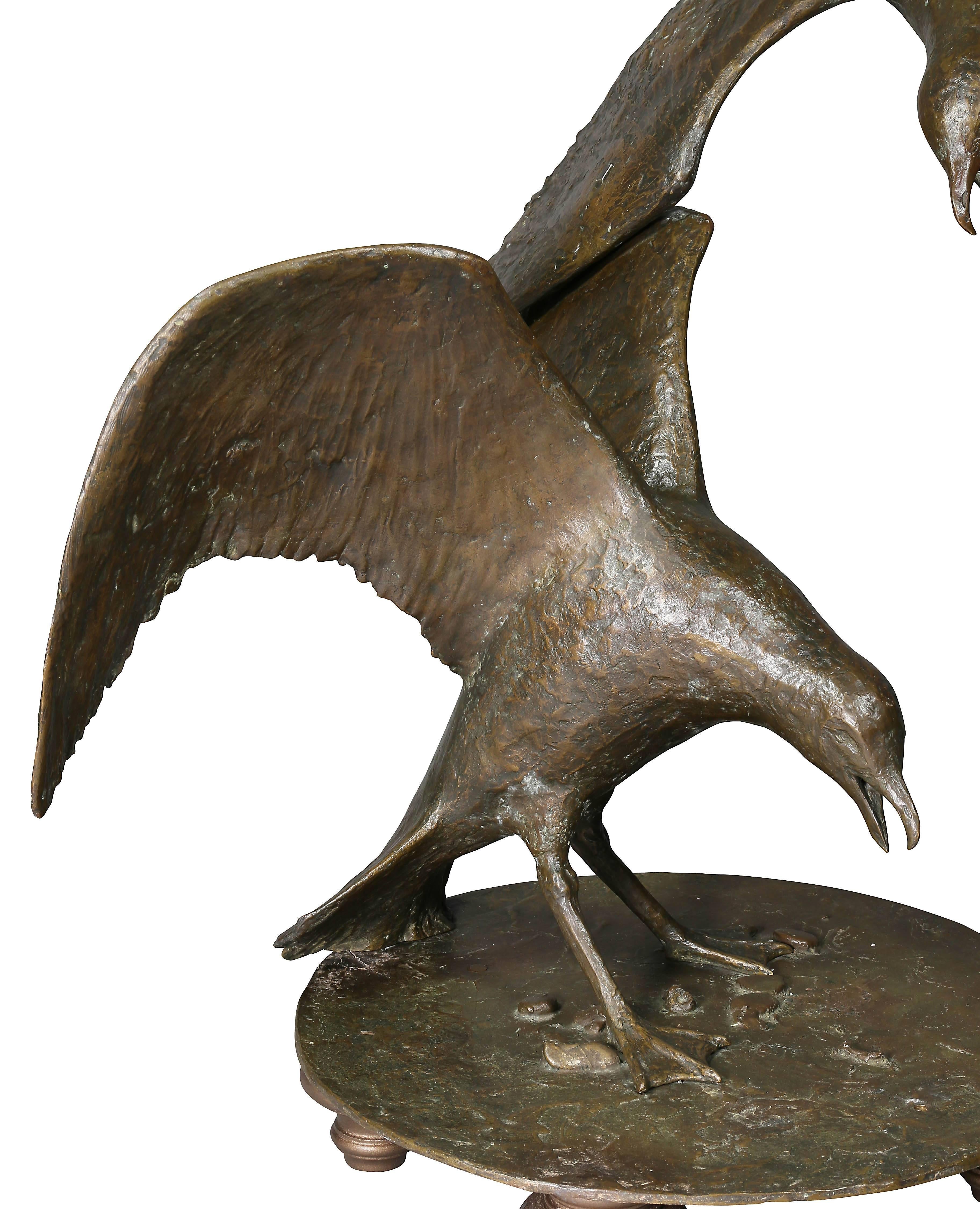 An outdoor sculpture with feet added and easily removable when installed outdoors. Signed in two places Beverly B. Seamans, 1971. In two sections with swooping gull crossing over a gull with wings stretched back on a circular naturally cast base.