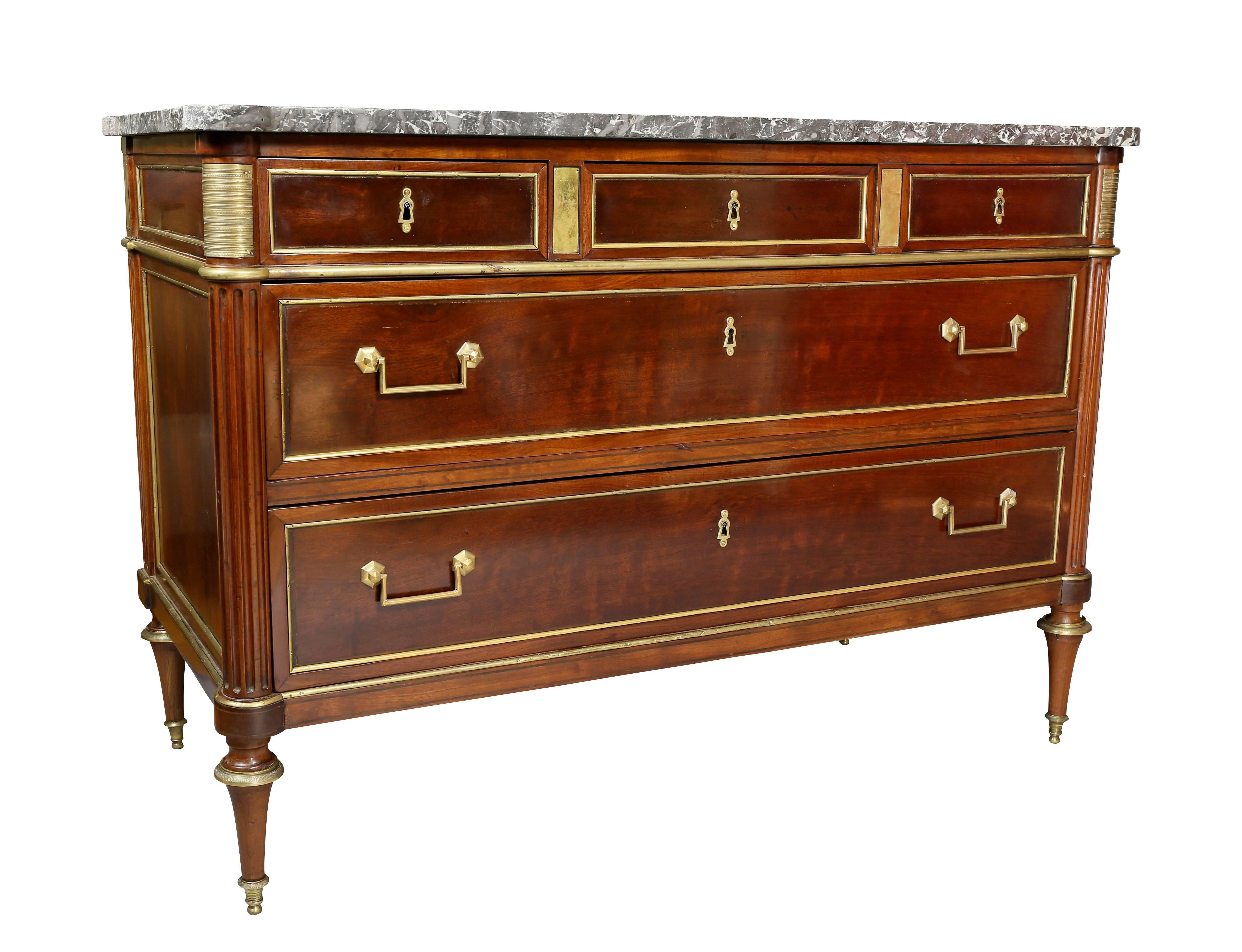 With rectangular grey and white marble top with rounded front corners over a conforming case with three drawers over two long drawers flanked by fluted columns raised on toupie feet. Stamped on top E. Mariage.
