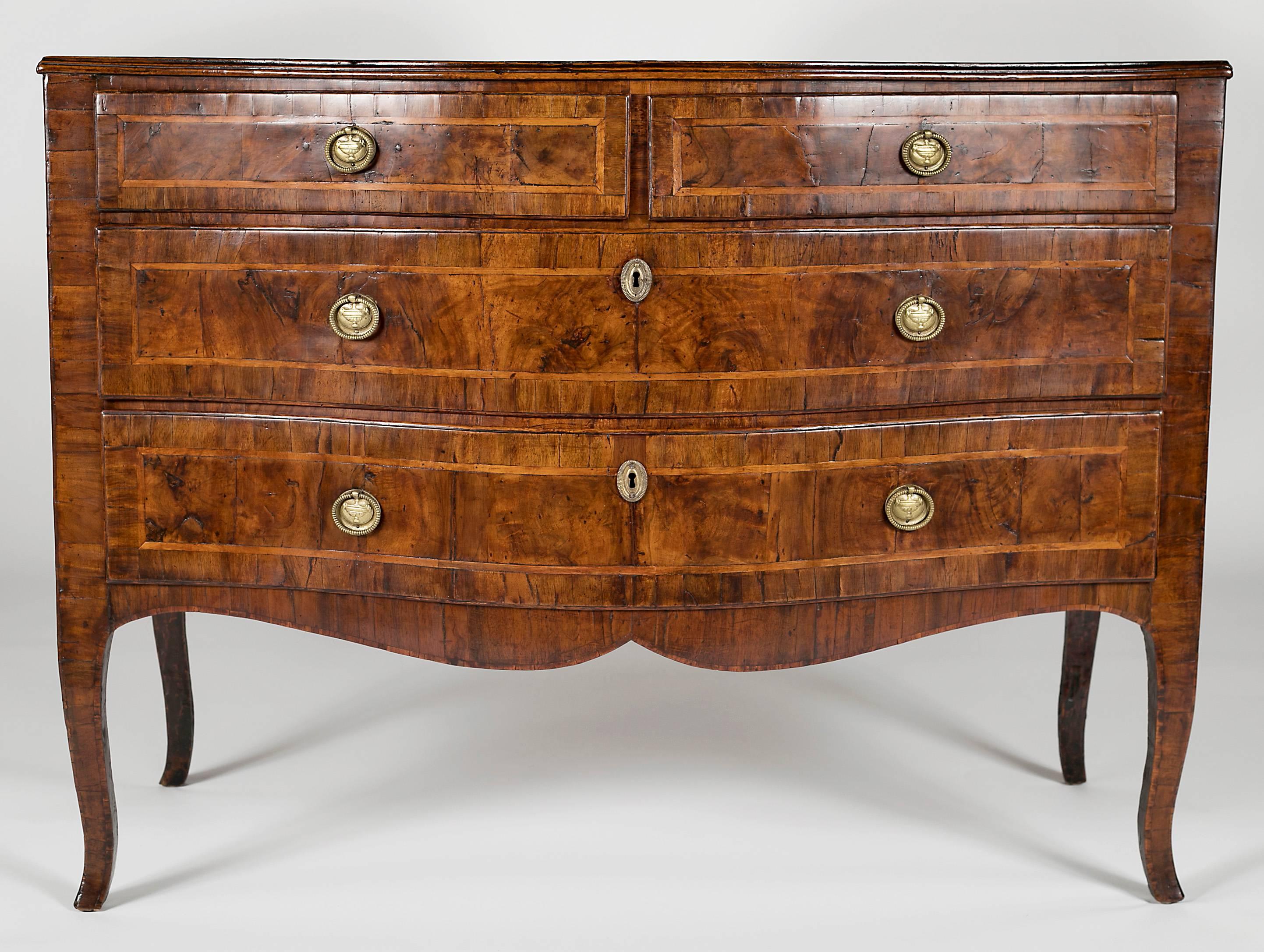With a serpentine top with crossbanded edge over two drawers over two long drawers raised on cabriole legs. All with brass ring handles with back plates.