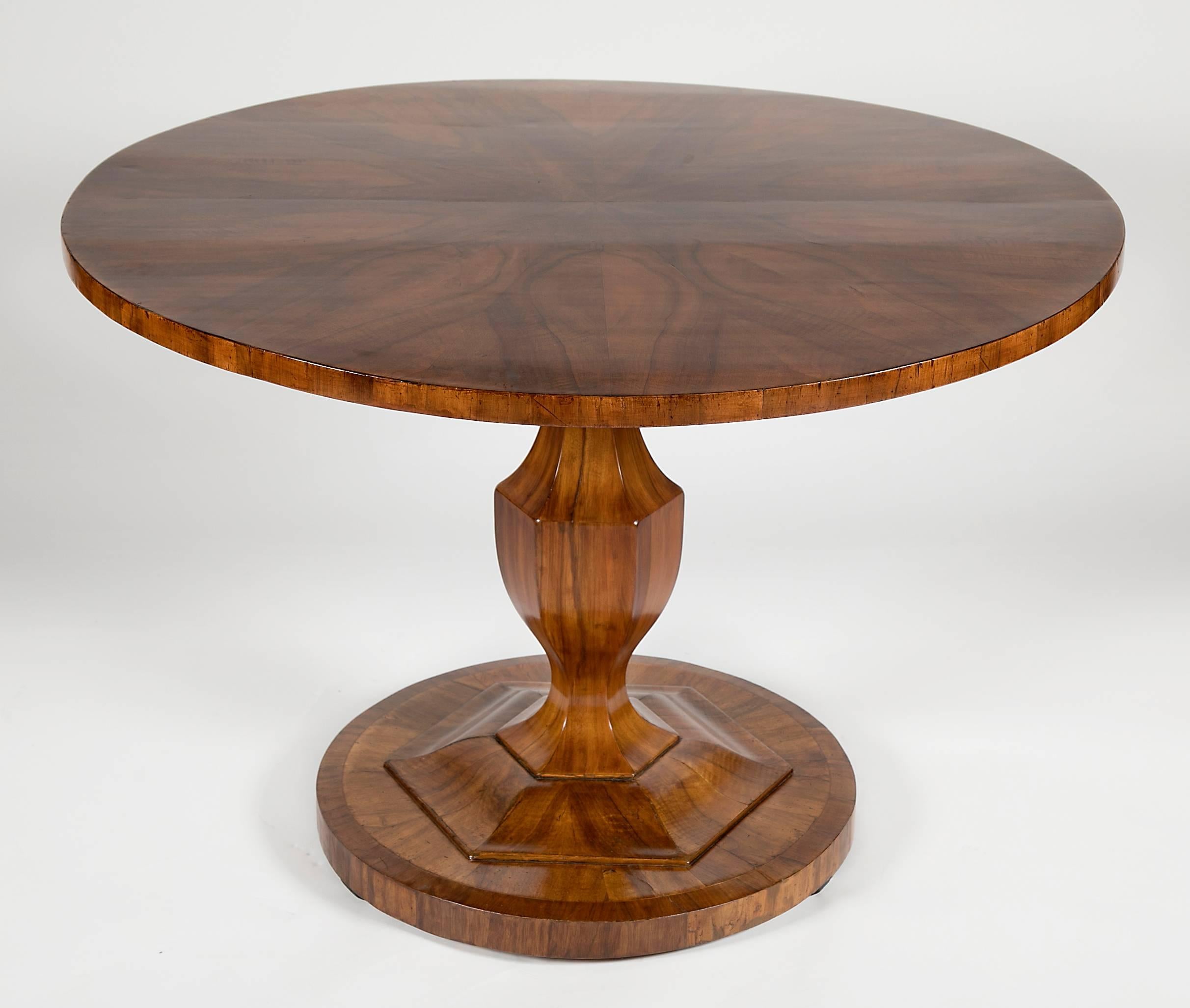 Circular top with wonderfully matched figured top over a shaped vase form support ending on a circular plinth base.