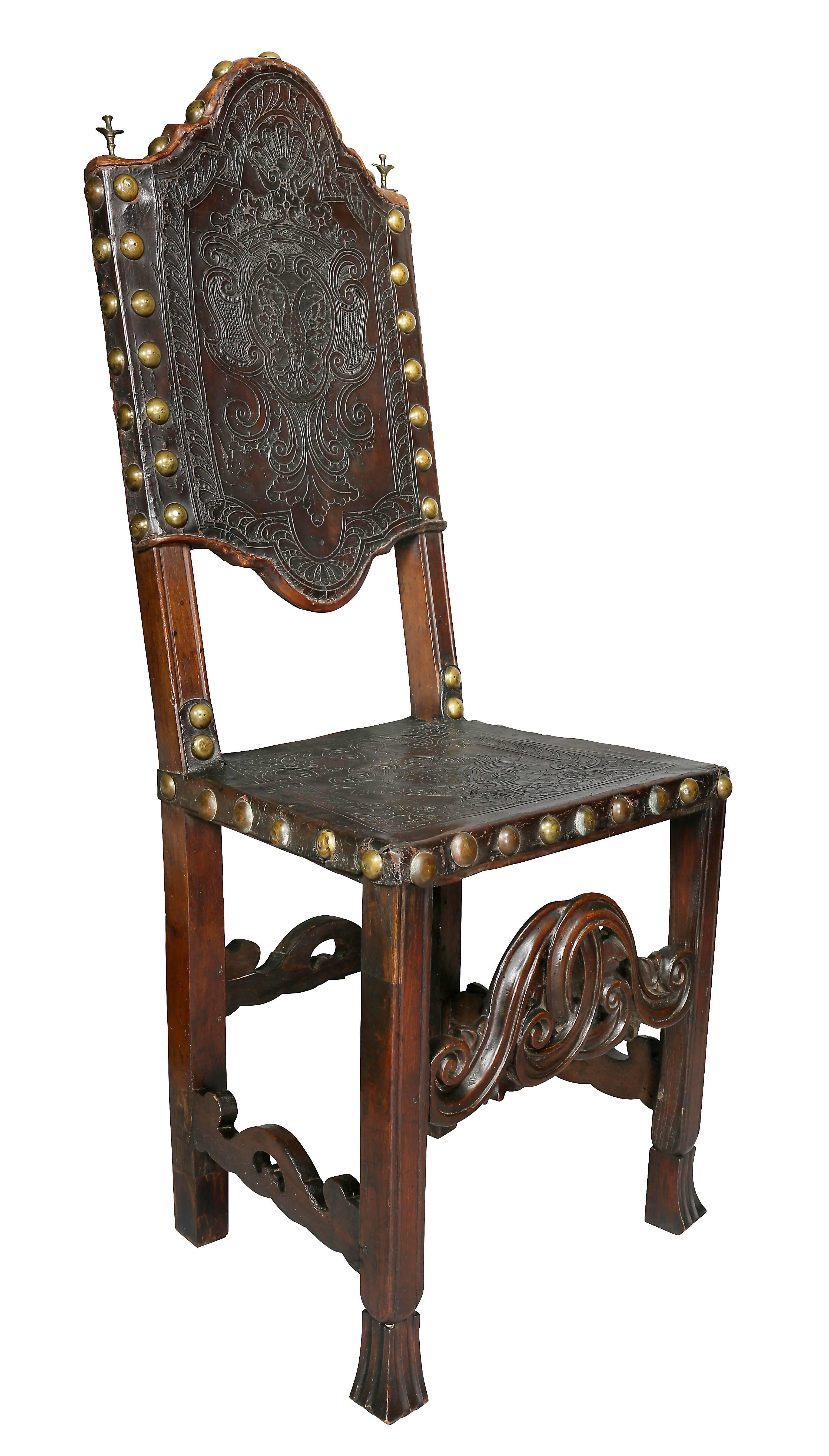 Each with arched embossed leather backs and square seats raised on molded legs with carved stretchers.