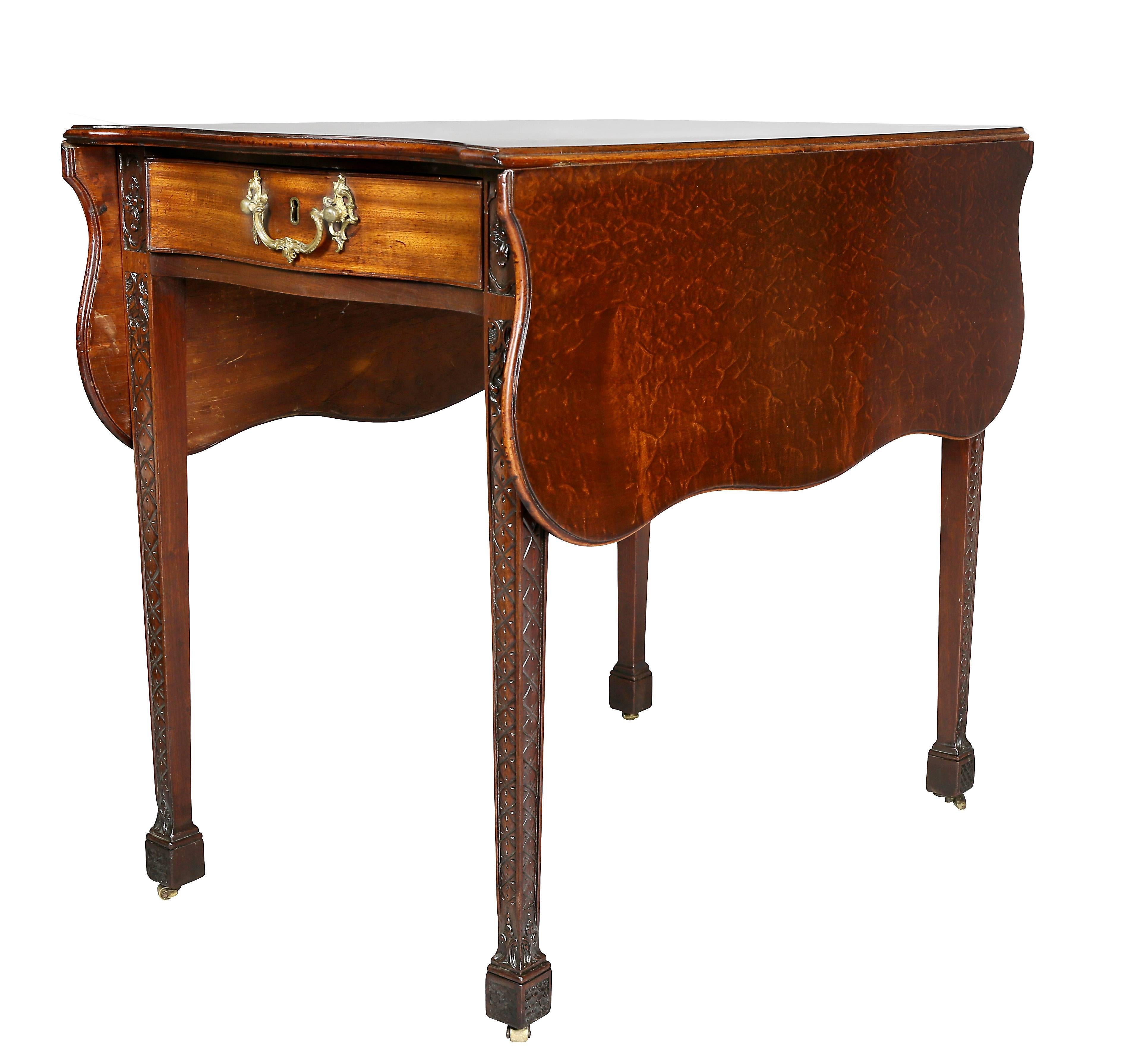With a finely figured top resembling lacewood with serpentine leaves over a serpentine drawer and false drawer on reverse end. Original cast gilt bronze rocaille handles, carved square tapered legs ending on casters.