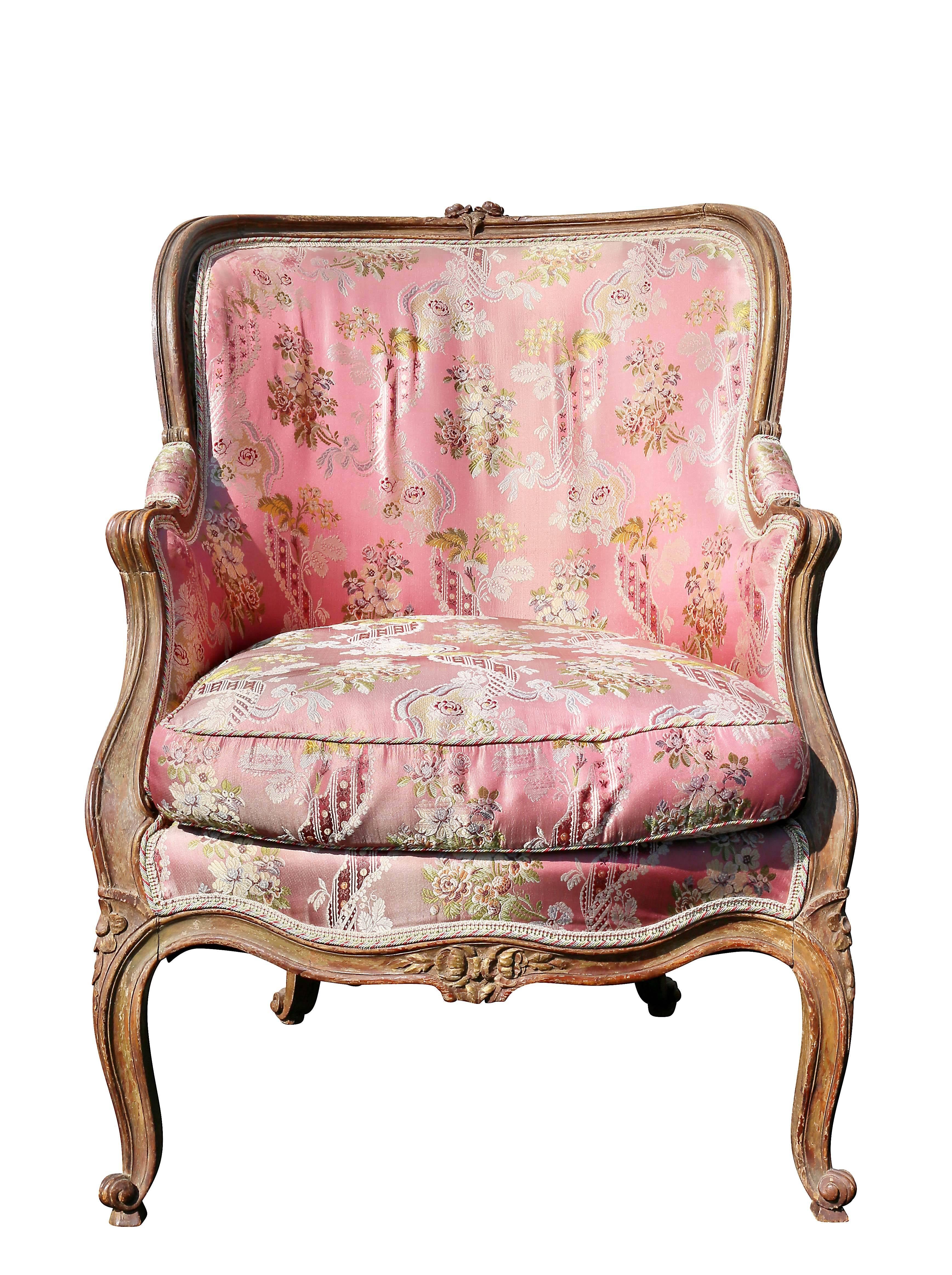 With rounded arched back with central flower heads, upholstered back and seat, carved scrolled arms, raised on cabriole legs.