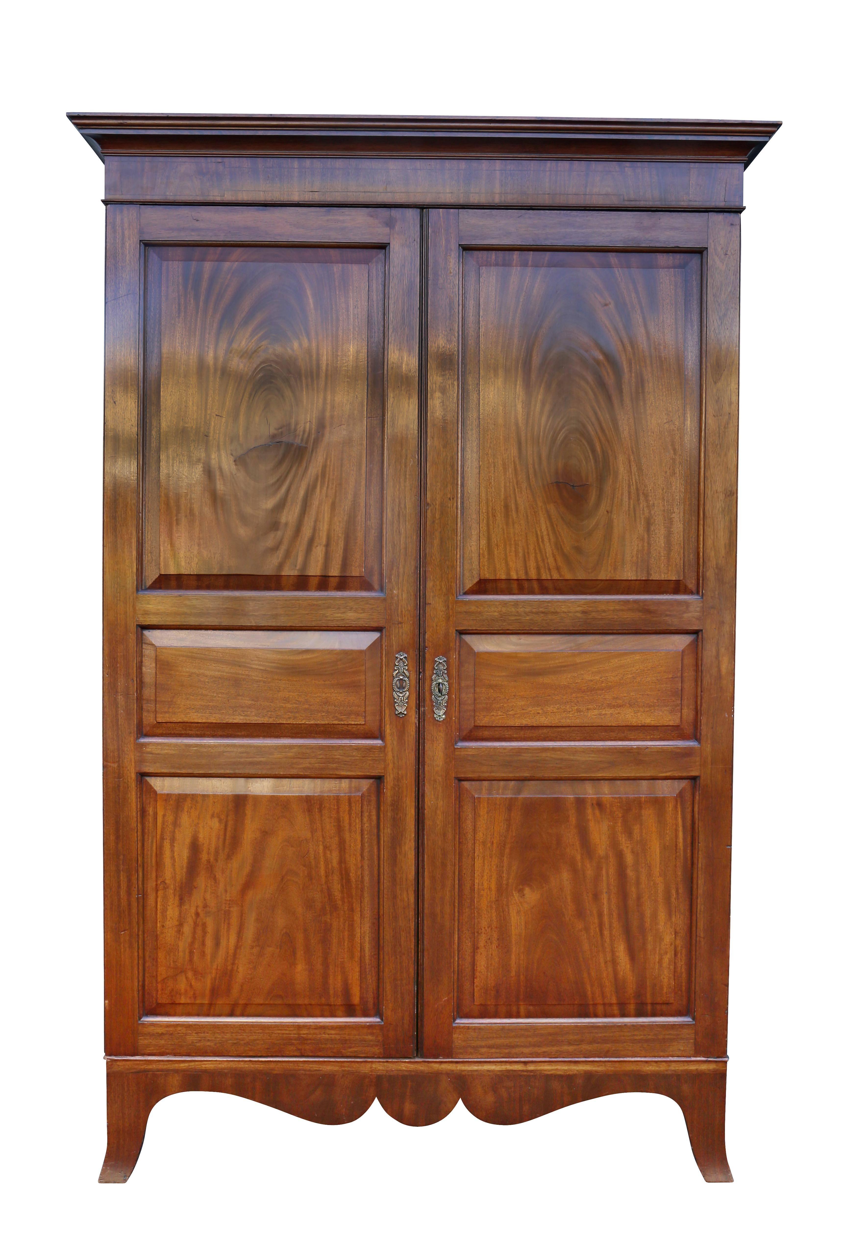 With a dentilled cornice over a pair of panelled doors, sides panelled also, raised on splayed legs. Inside has brass coat rail. Wood nicely figured with a nice color.