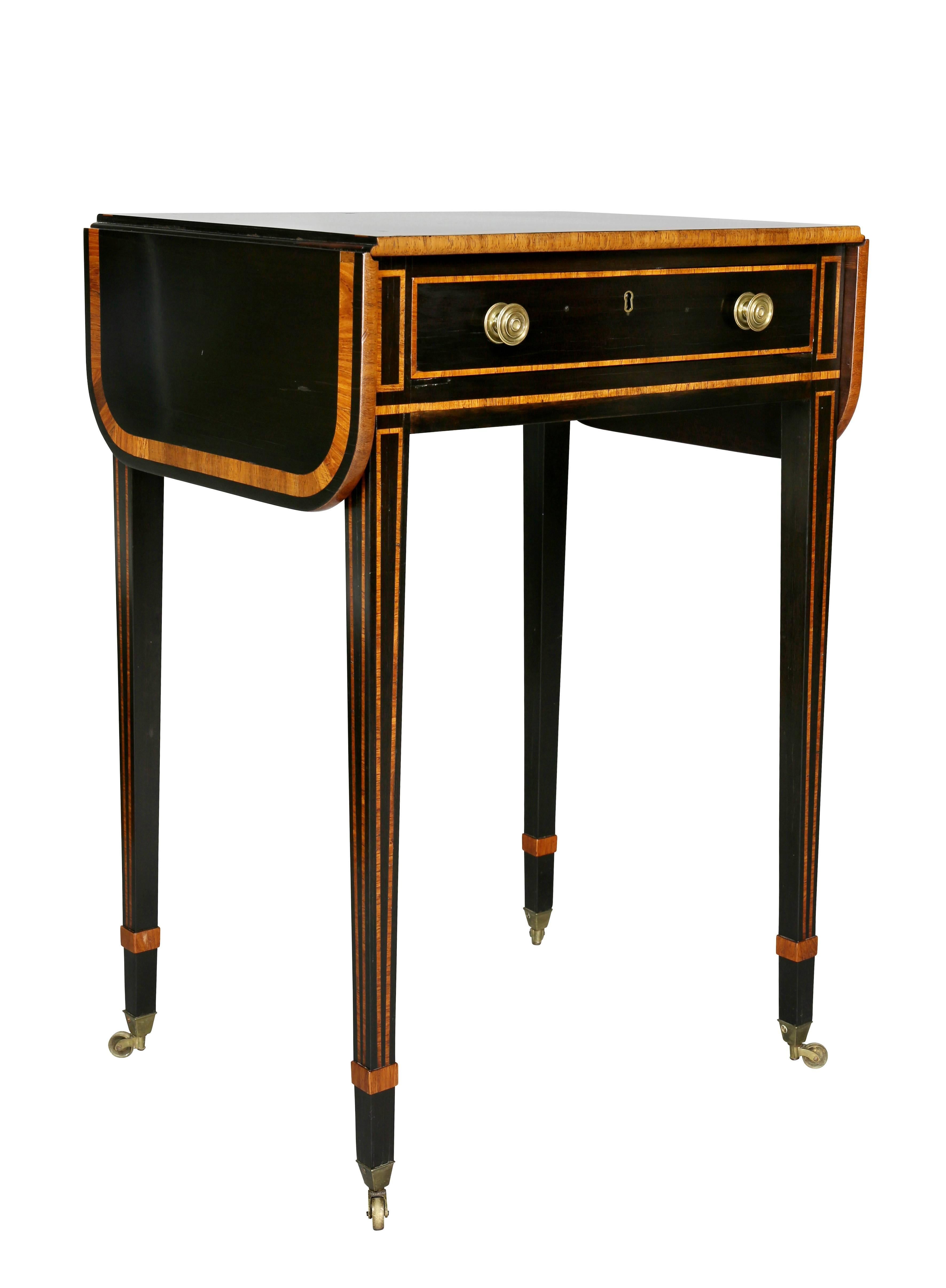 With rectangular top with drop leaves over a drawer, raised on square tapered legs, casters.