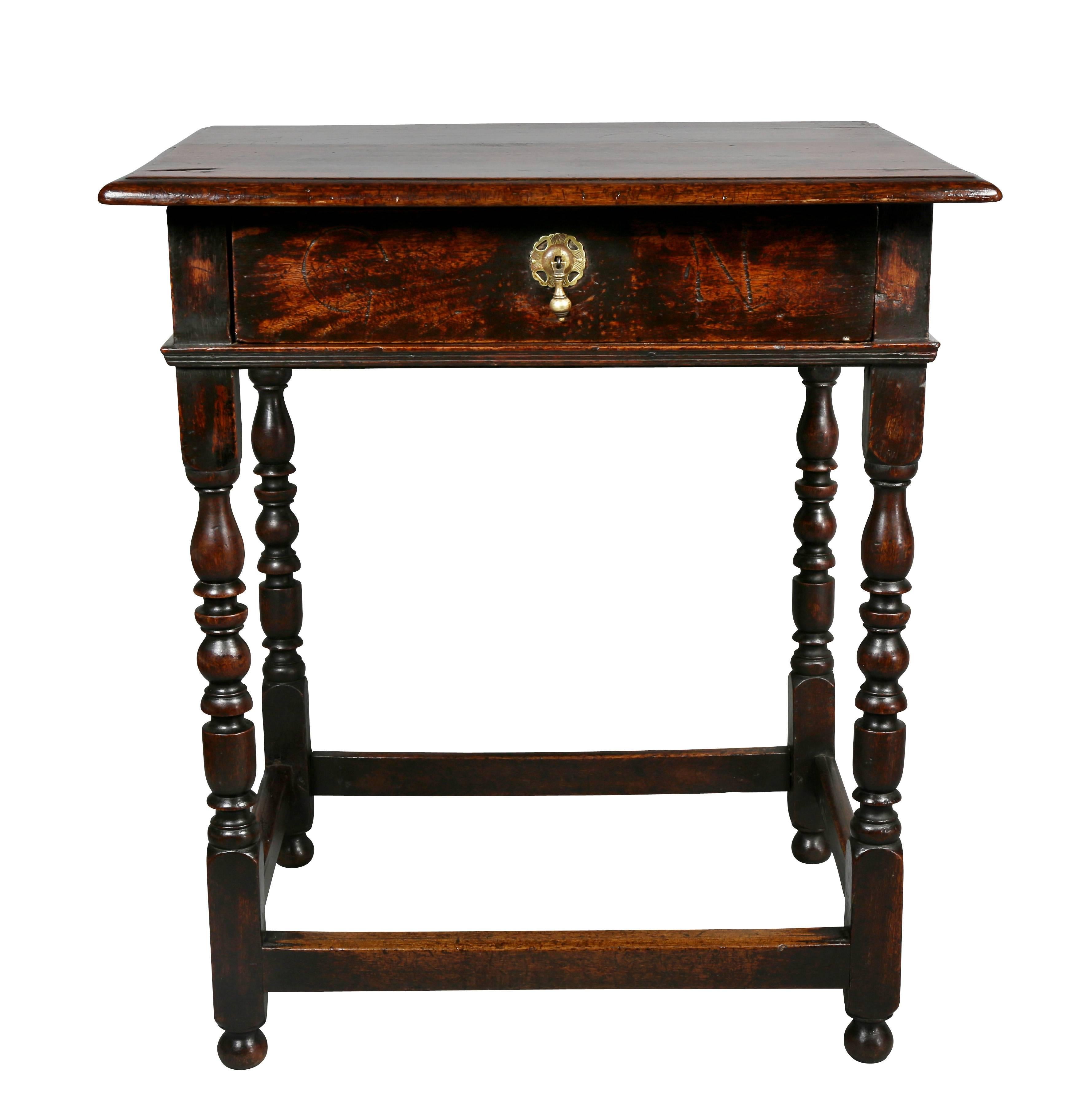Rectangular molded top over a drawer with engraved initials GN. Raised on turned legs and box stretcher, button feet.