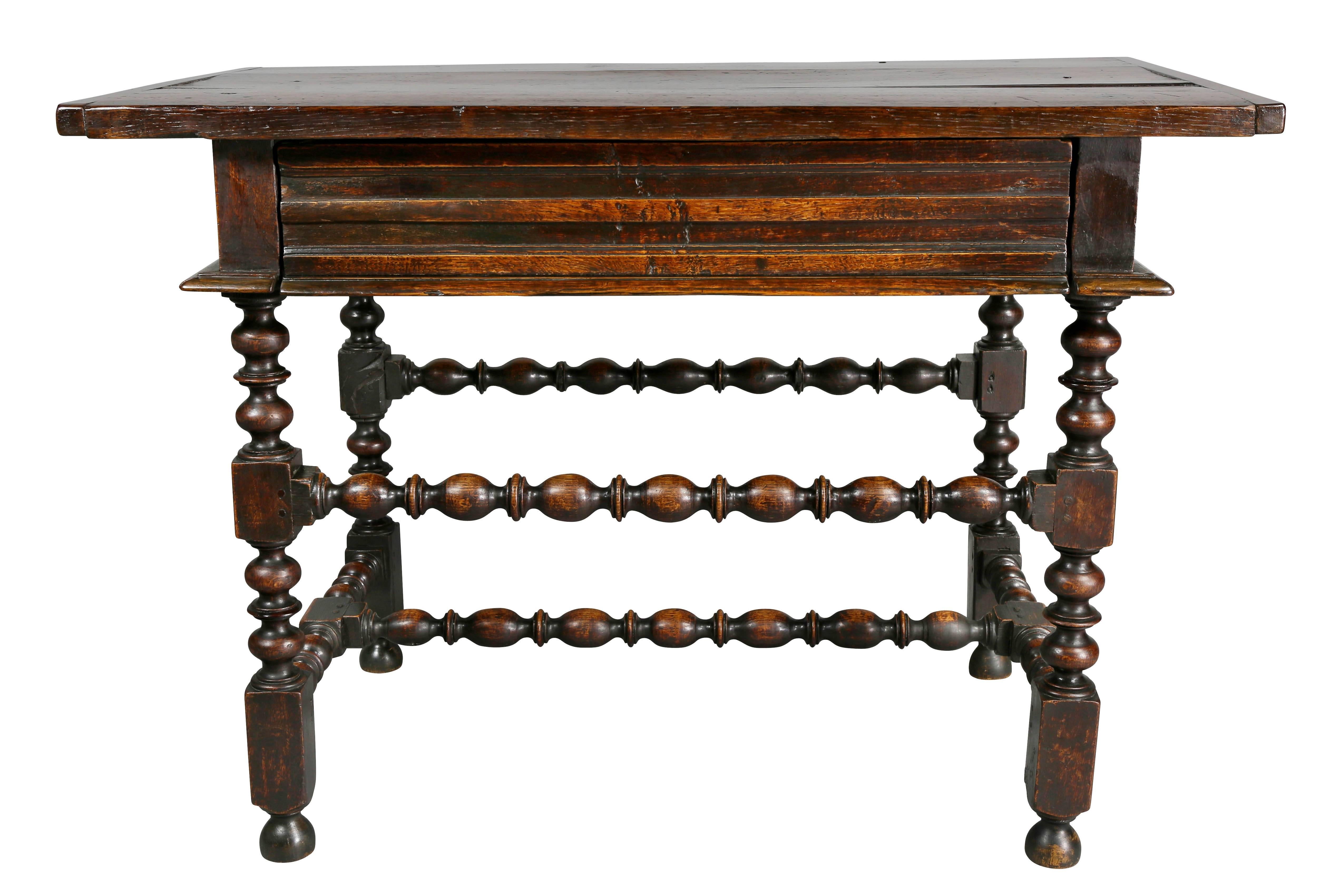 Rectangular top over a long drawer and raised on turned legs and stretchers.