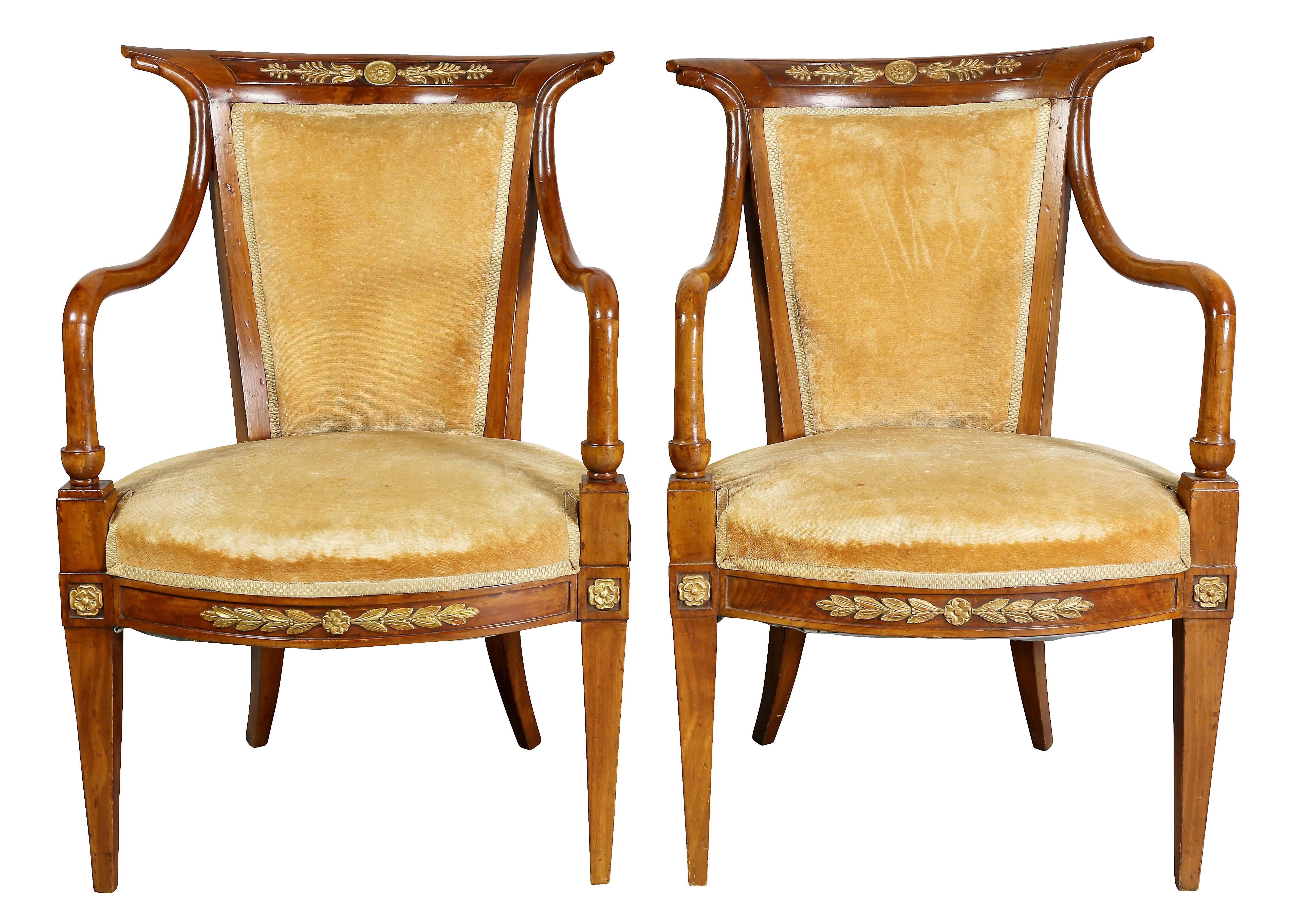 Each with panelled crestrail with central gilded anthemion and paterae, downswept arms, raised on slightly flared tapered legs with paterae, seatrail with carved details. Upholstered in gold velvet.