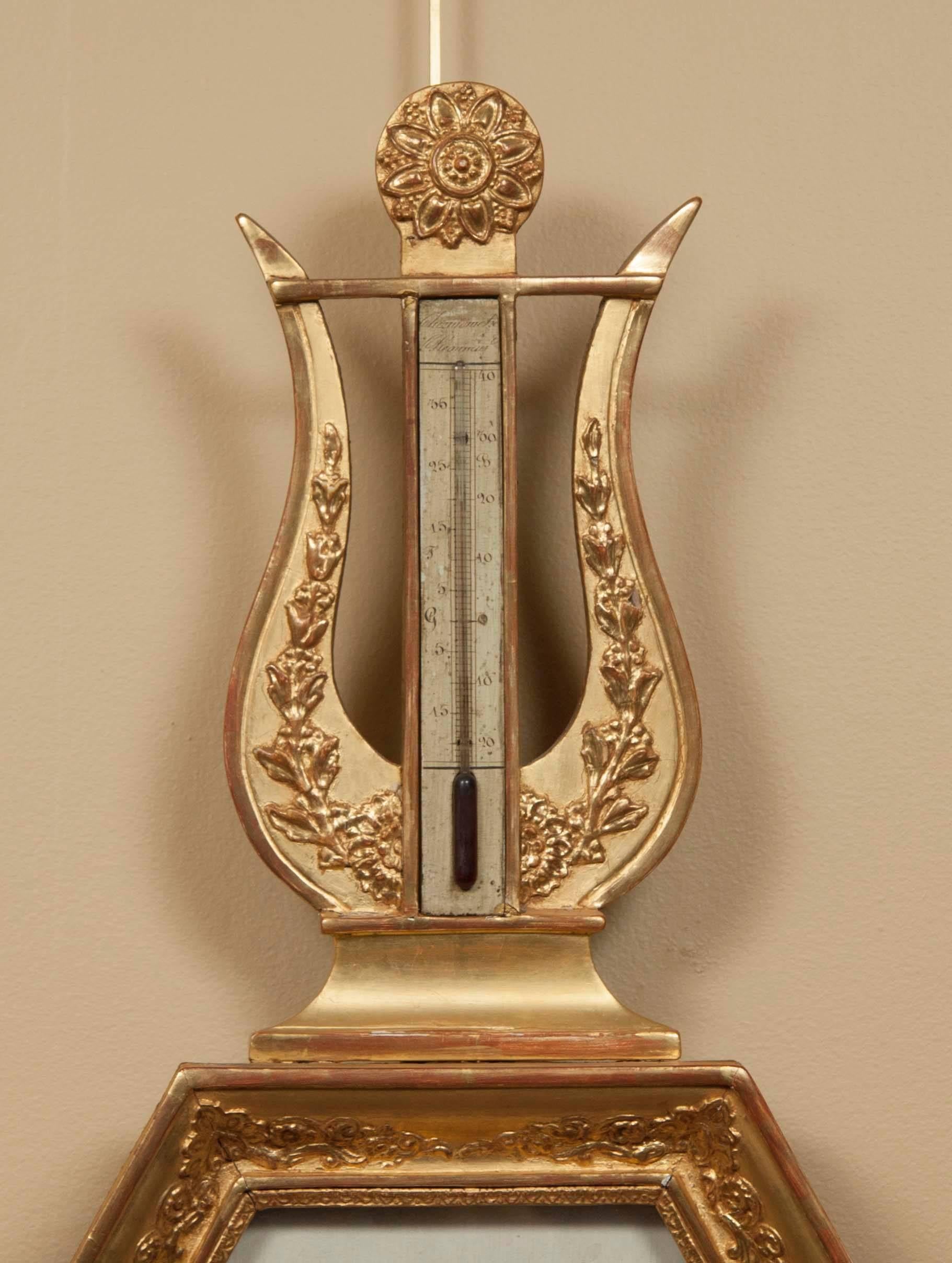 Typical form with lyre form top section with central thermometer, the central hexagonal frame with grisaille painted dial.
