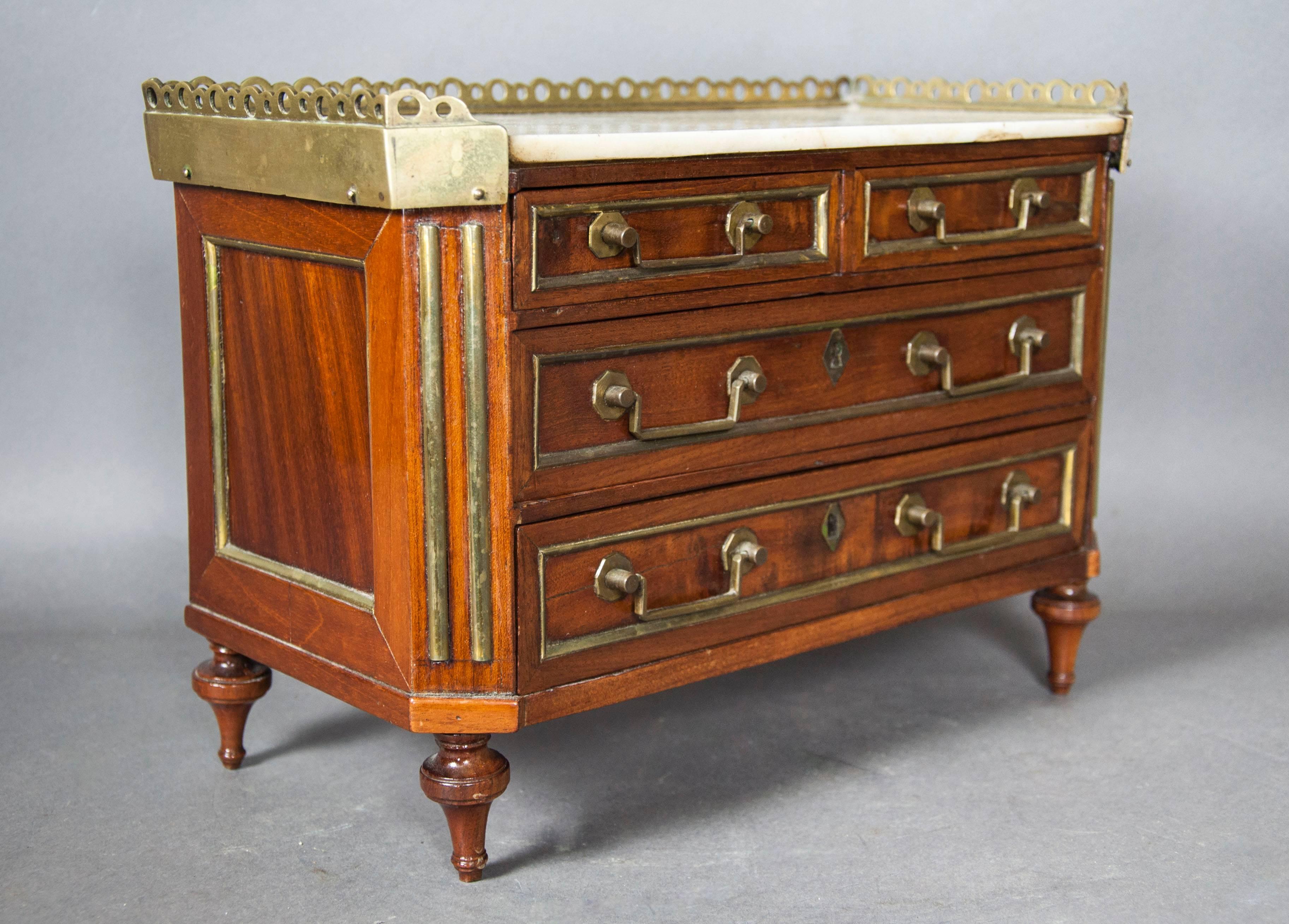Rectangular white marble top with brass gallery over two small over two long drawers , with chamfered brass reeding ends , raised on toupie feet.