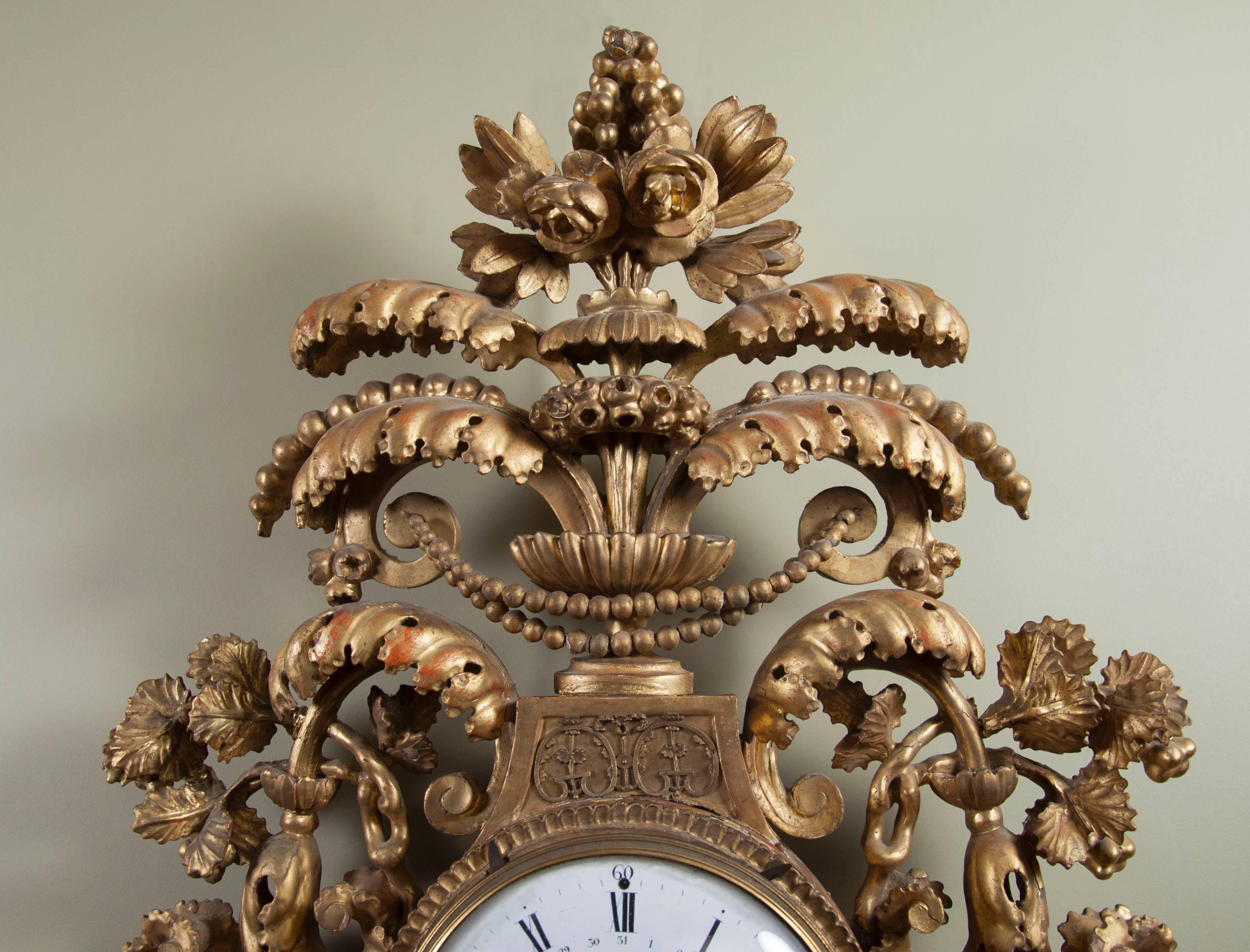 With urn superstructure with branches and flowing leaves and flowers , enamelled clock face  flanked by flowers and leaves over a section where the pendulum hangs flanked by mythological birds with lower leaves and berry cluster. Original works.