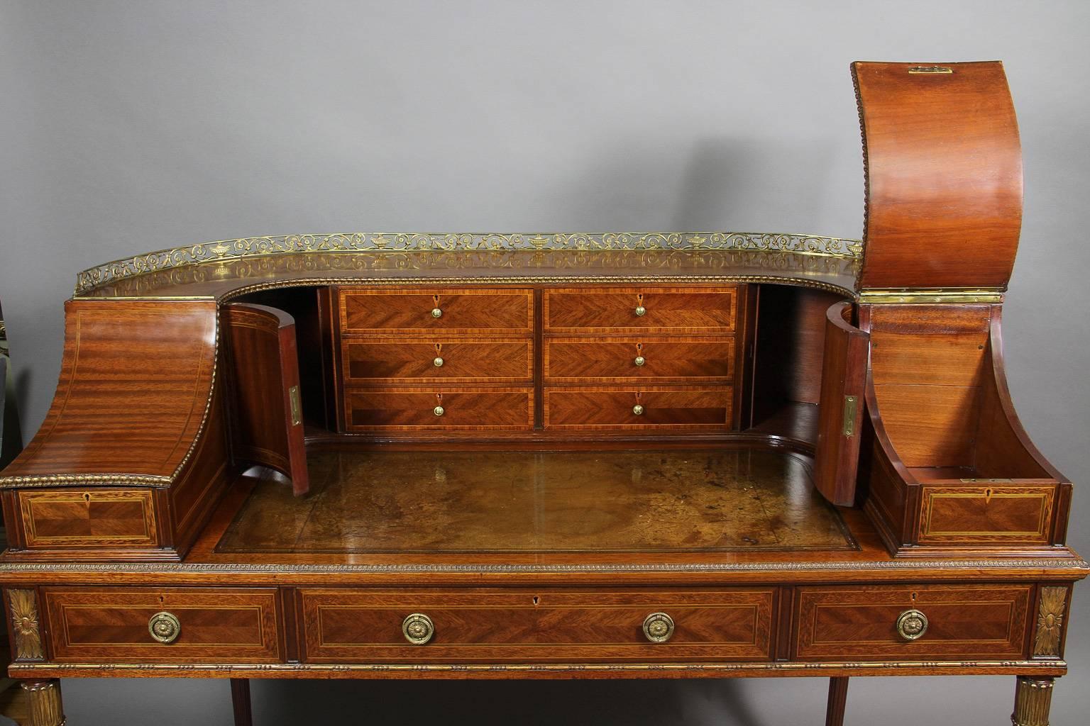 With gilt bronze rail with wraparound drawer and compartment section over a leather writing surface over three drawers raised on circular tapered legs with toupie feet. Signed Gillows on lock plates. Gillows of Lancaster was a Fine furniture