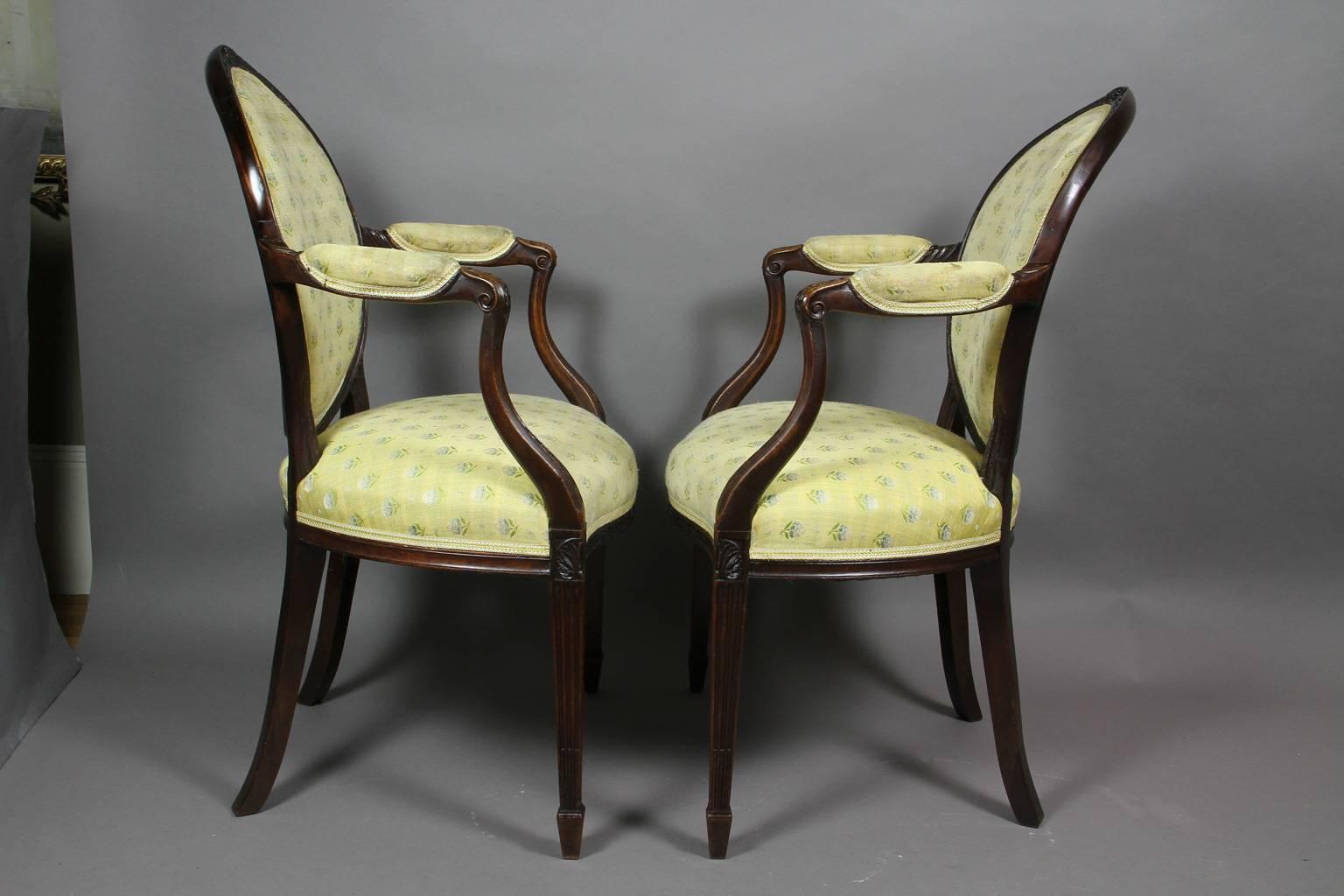 Oval upholstered back with oval carved paterae and bellflower crestrail , carved downswept arms and serpentine upholstered seat raised on stop fluted tapered square legs , spade feet.