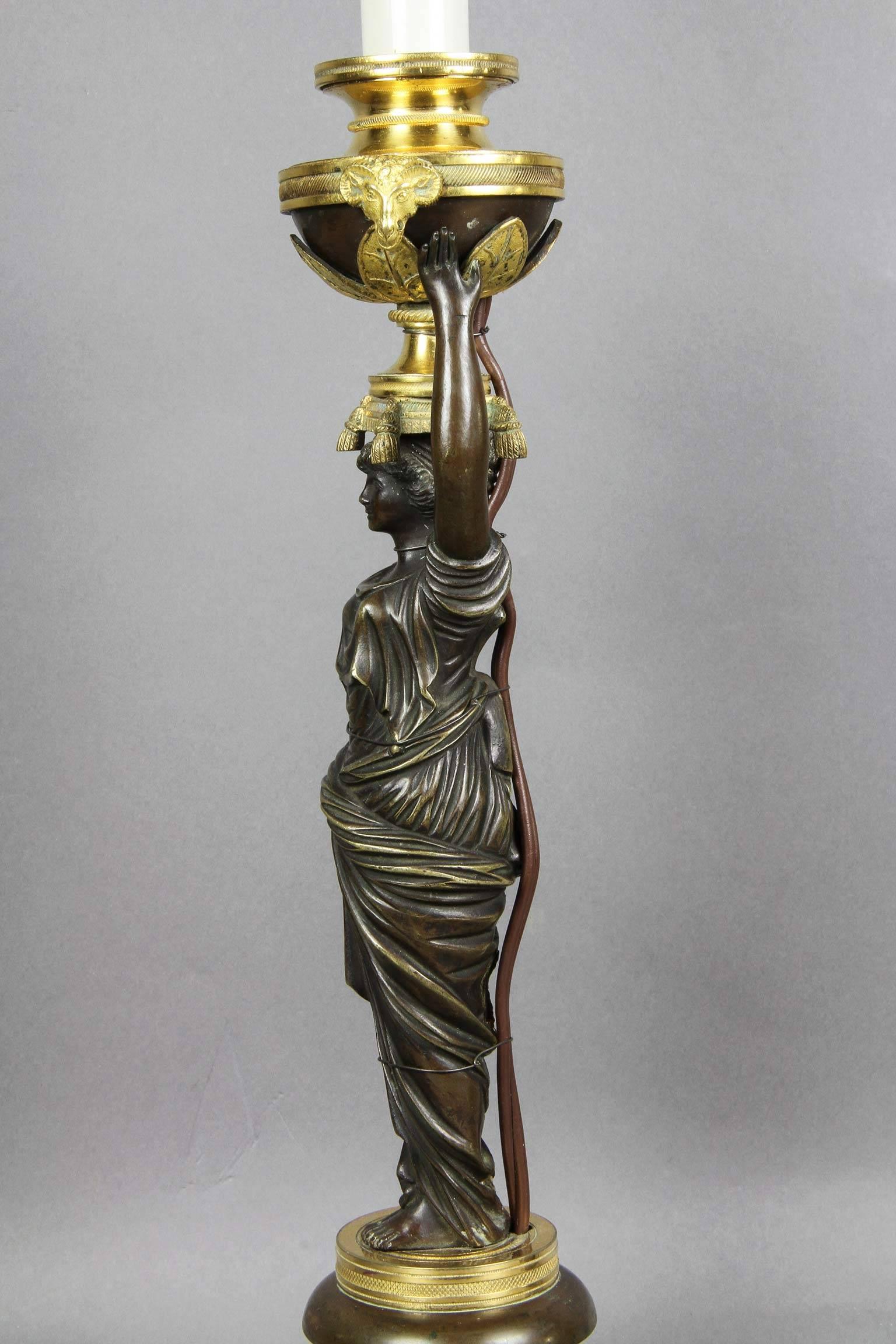 Originally one of a pair of figural candlesticks. Finely cast and chased with a candleholder now fitted with a two light modern fixture. The candleholder finely detailed with a pair of rams heads and leaves being held up by a classical maiden with