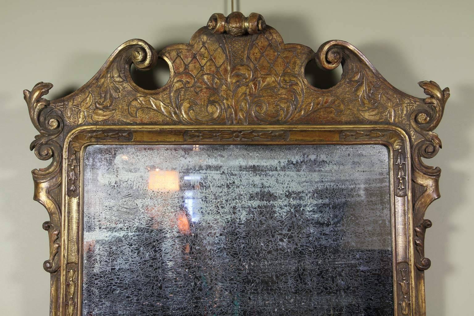 With old distressed mirror plate set in a nicely carved and gilded frame.