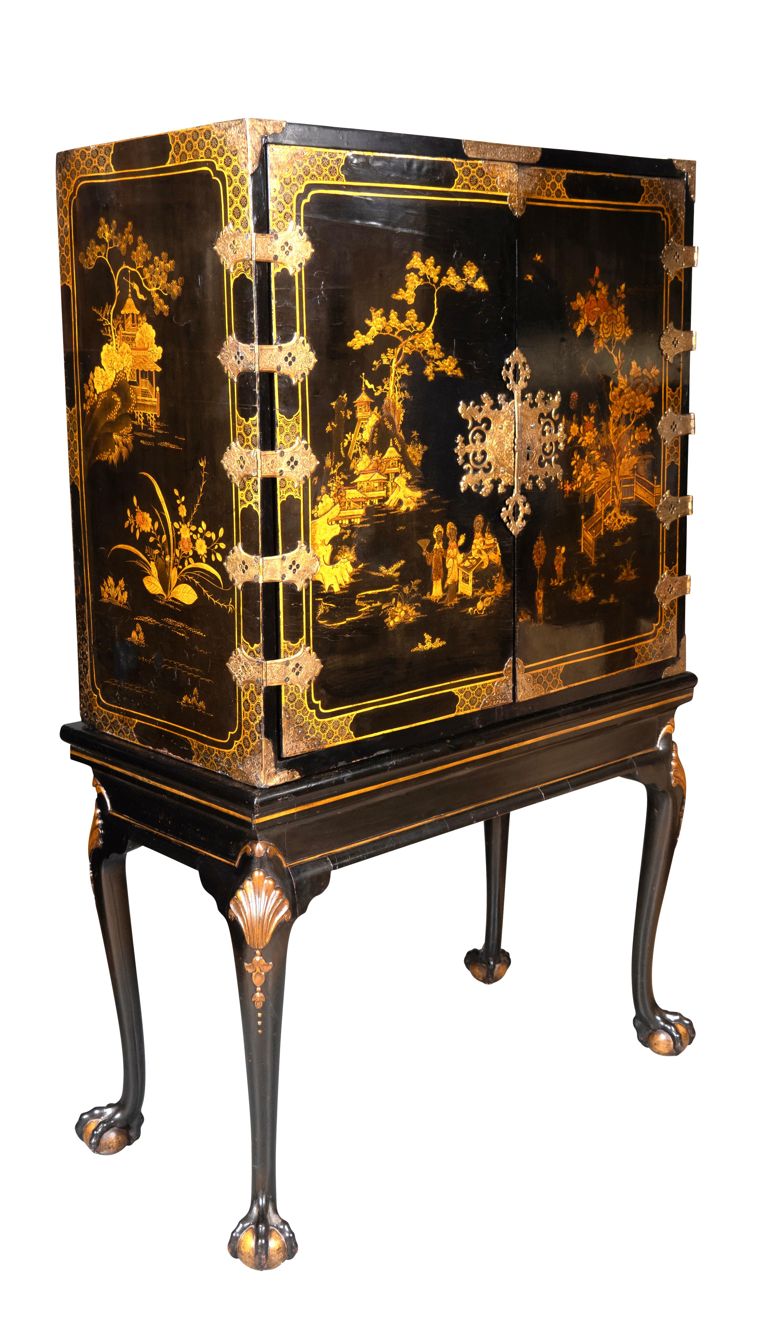 In ottime condizioni. Con una coppia di porte con elaborate cerniere in ottone che si aprono su un interno dotato di cassetti con maniglie ad anello in ottone. La base, aggiunta cento anni dopo, presenta gambe cabriole dorate e piedi a sfera.