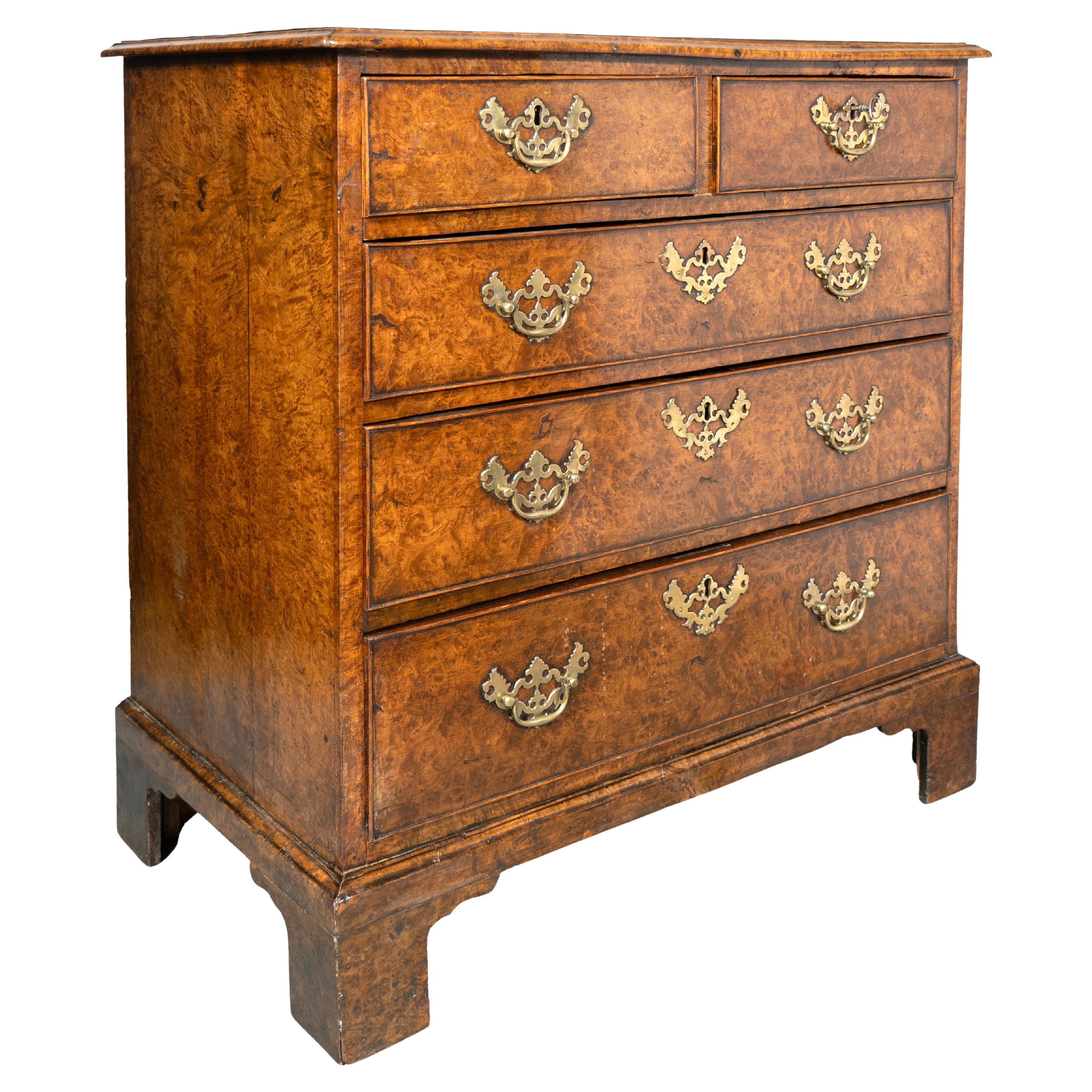 Rectangular top with molded edge over two over three drawers with original pierced brass handles. Bracket feet.