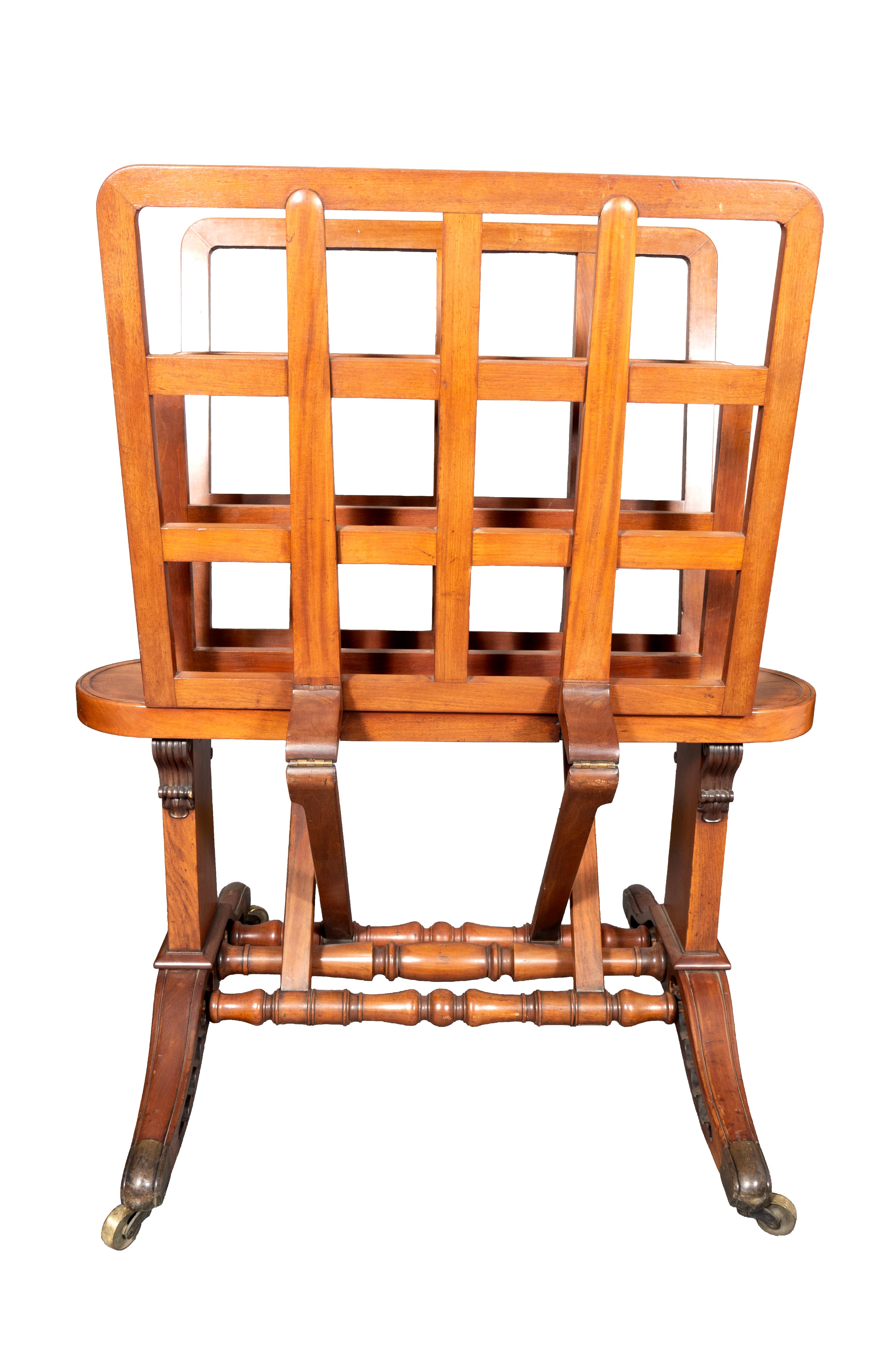 Width fully open 61.5 inches. With two adjustable lattice form leaves with center panel. Turned stretchers that also lift with your foot to adjust the folio opening. Saber legs with brass cup casters. Stamped Holland & Sons.