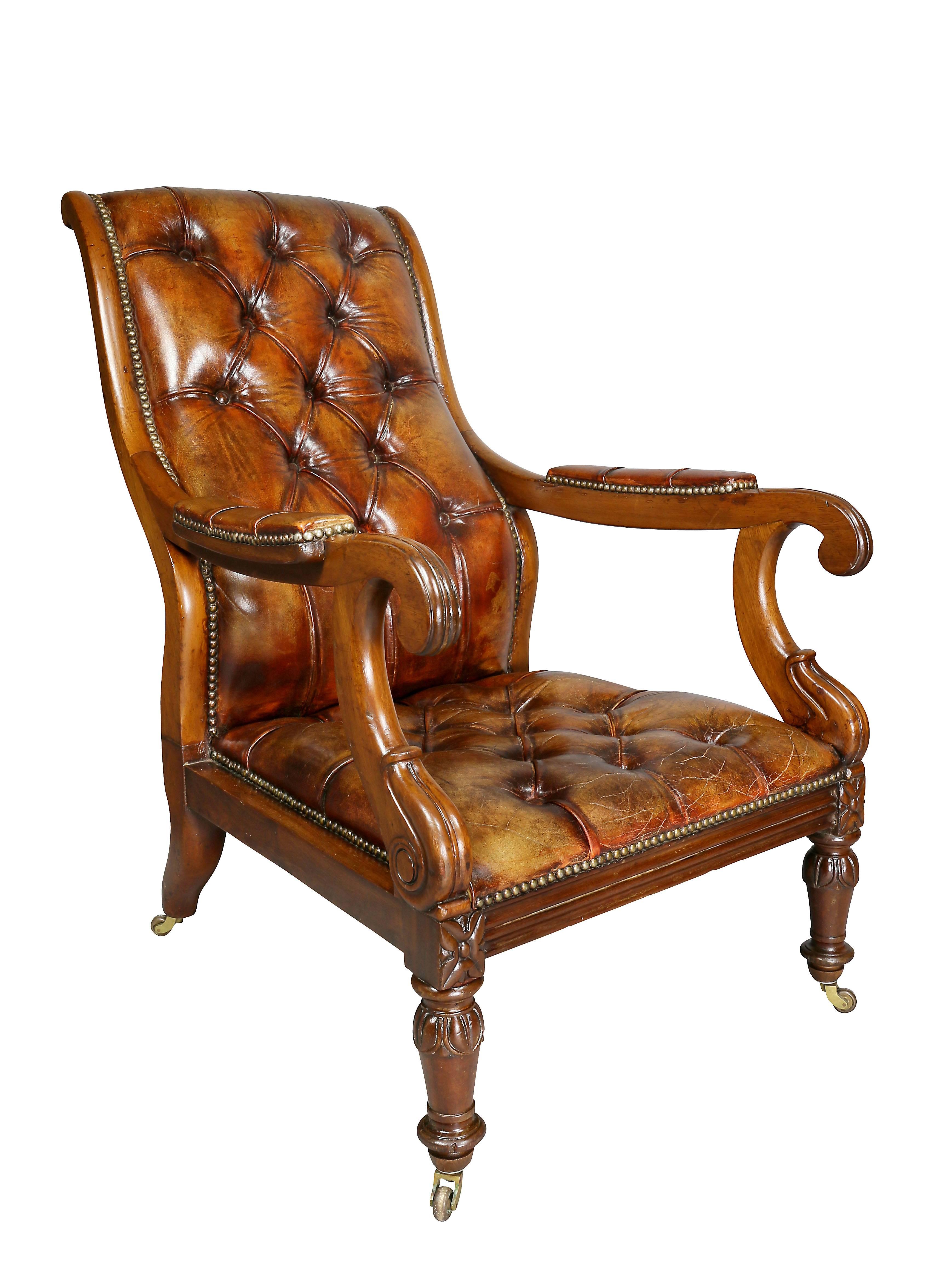Each with curved tufted brown leather backs and scrolled arms and square conforming seats raised on circular tapered legs carved with leaf tips ending on casters. These chairs are featured in the movie Knives Out.